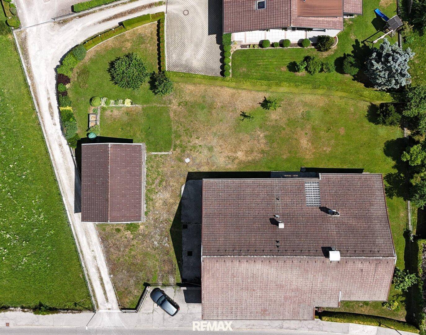 Luftaufnahme des Anwesens mit großem Grundstück, Nebengebäude und umliegender Landschaft.