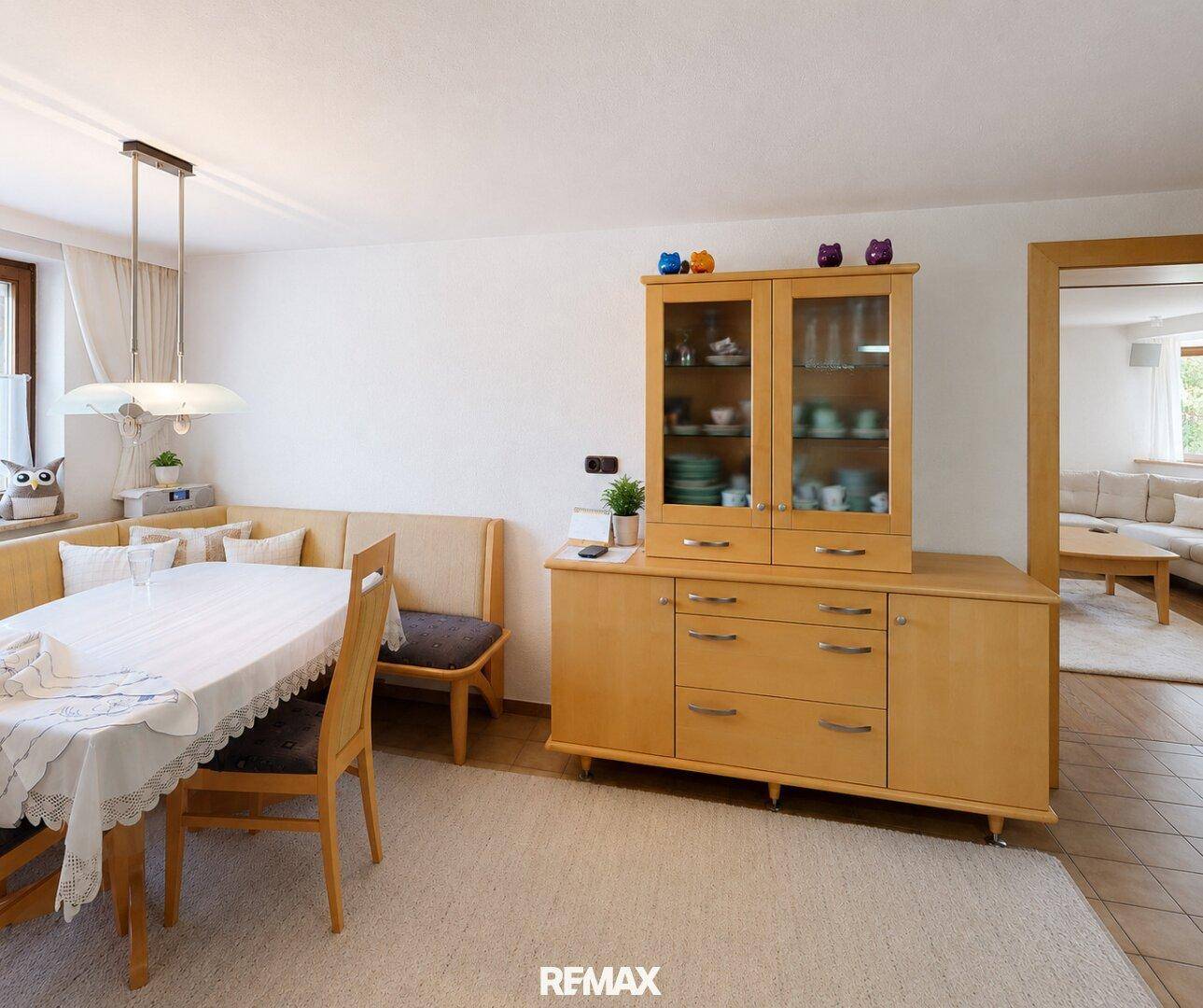 Heller Essbereich mit Holztisch, Sitzbank und Zugang zum Wohnzimmer.