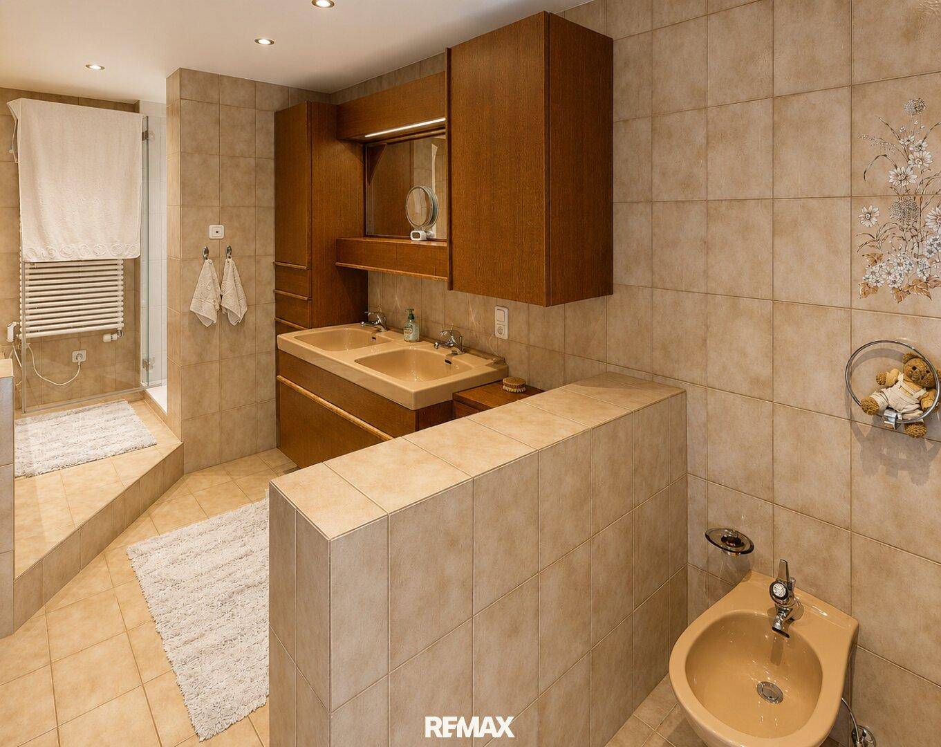 Geräumiges Badezimmer mit Doppelwaschbecken, Bidet und ebenerdiger Dusche.