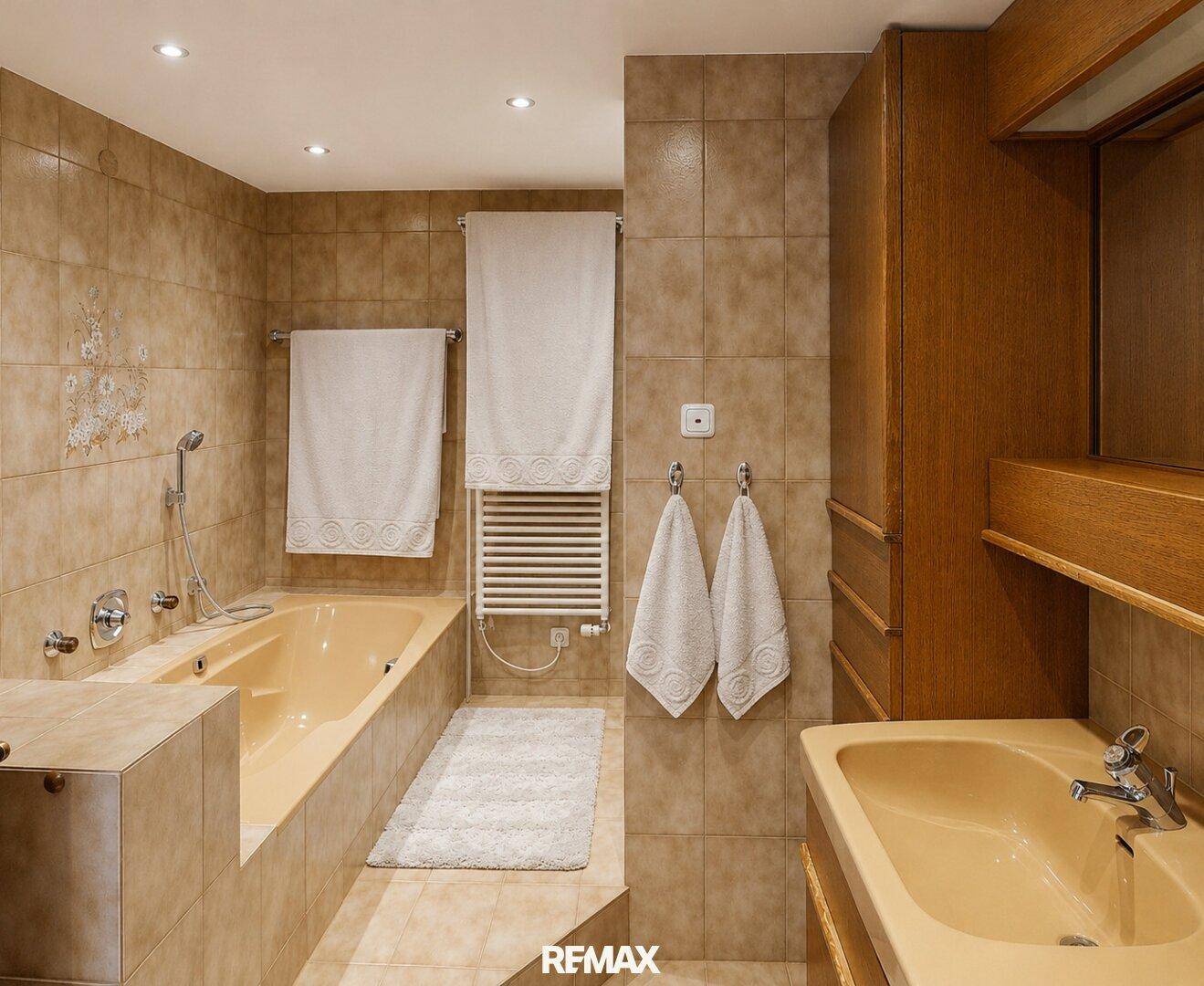 Helles Badezimmer mit Badewanne, Einzelwaschbecken und beigefarbenen Fliesen.