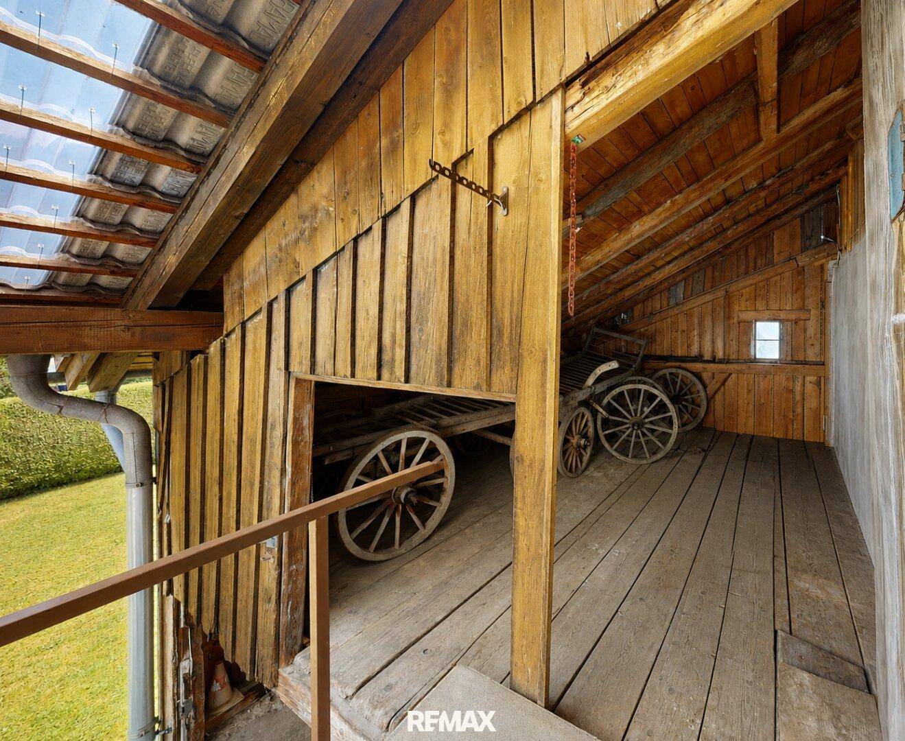 Rustikaler Dachboden mit Holzboden und gelagerten historischen Wagenrädern.