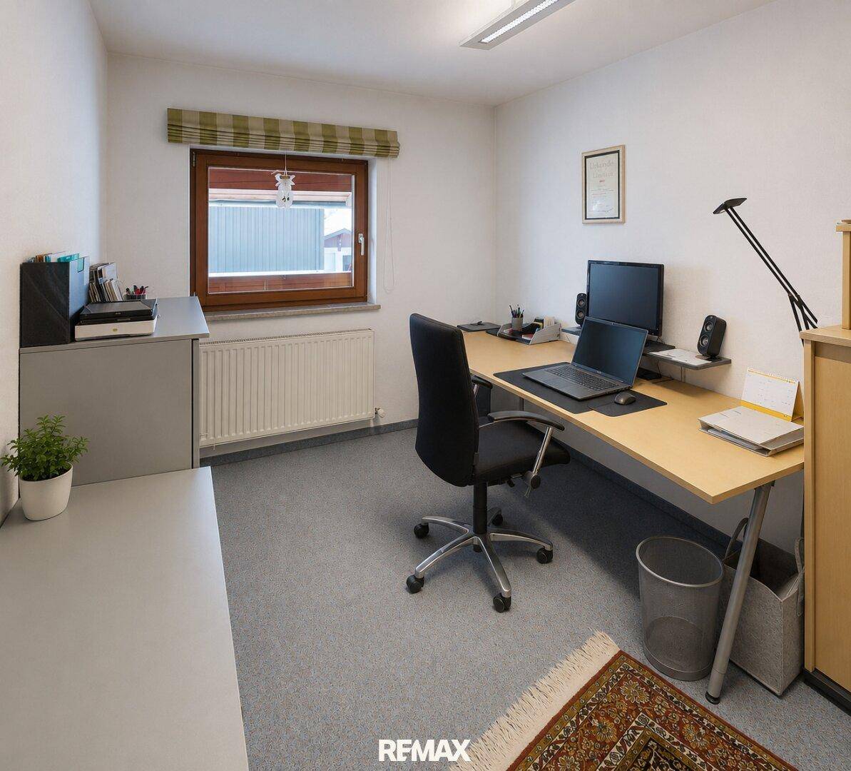 Funktionales Arbeitszimmer mit Schreibtisch, Bürostuhl und Teppichboden.