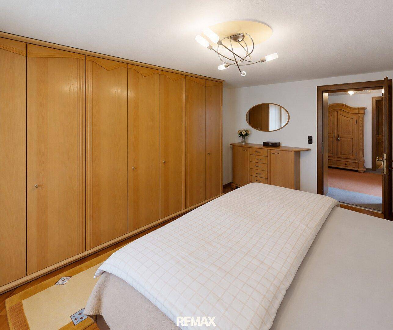 Geräumiges Schlafzimmer mit Einbauschränken, Doppelbett und Teppichboden.