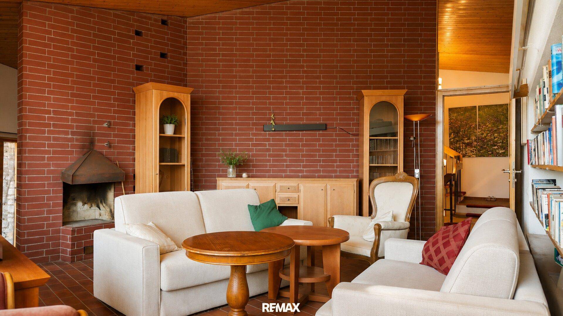 Geräumiges Wohnzimmer mit bequemen Sofas, Holztischen und einem traditionellen Kamin.