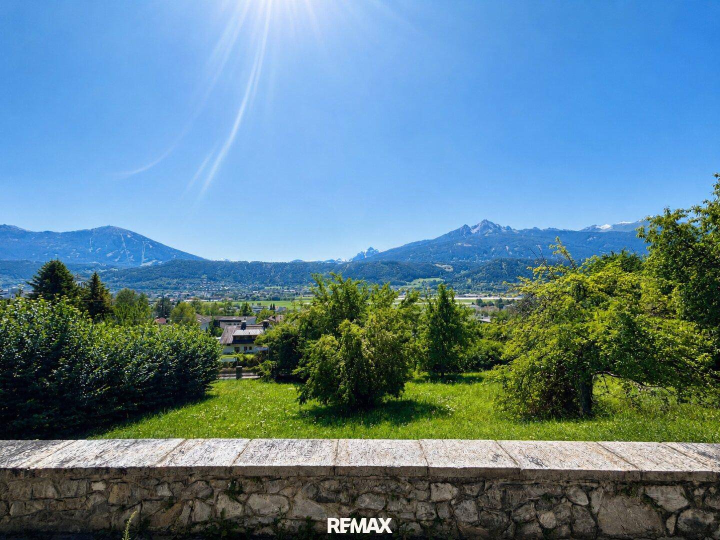 Heller Panoramablick auf die Berge und die grüne Landschaft an einem sonnigen Tag von einer Terrasse.