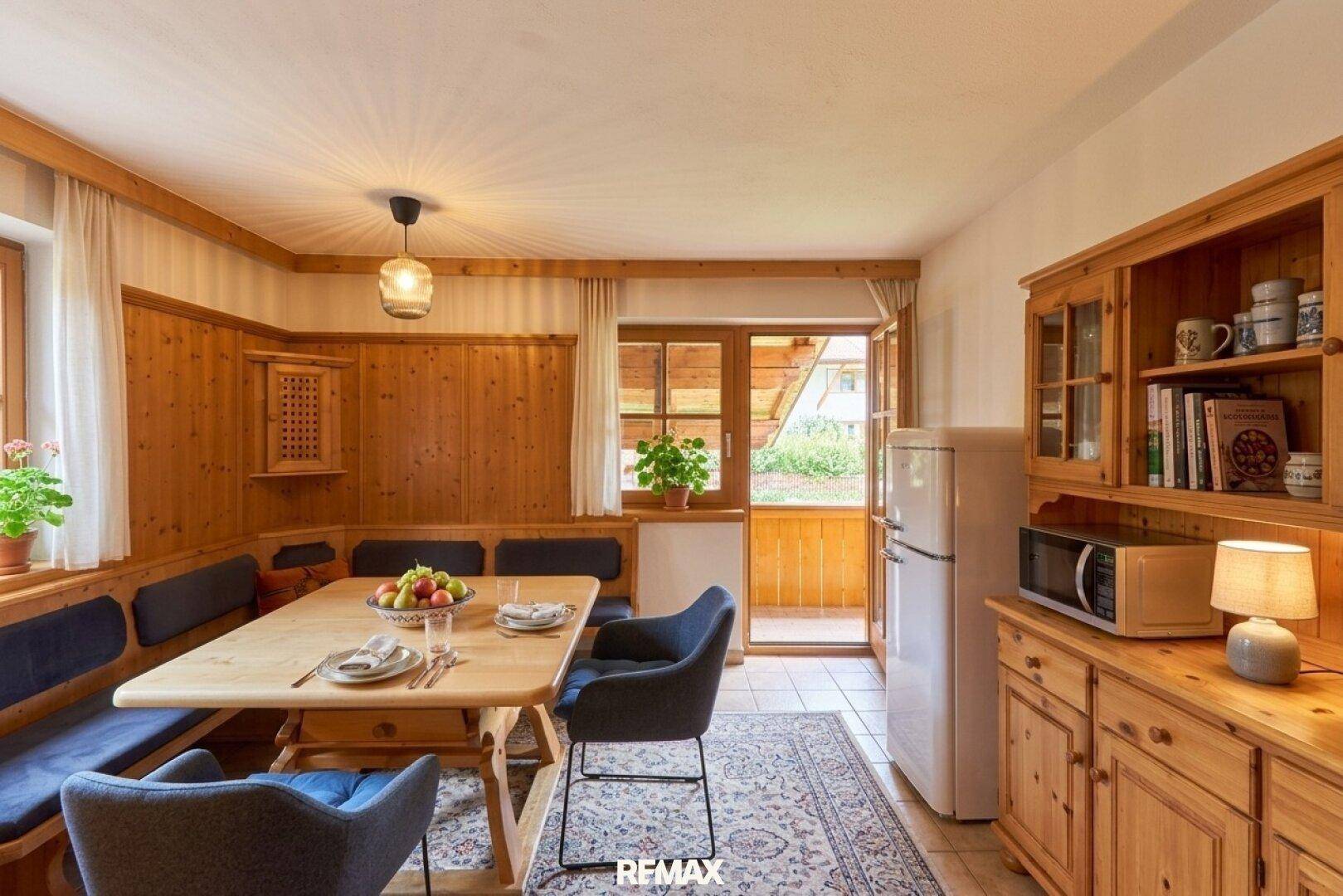 Gemütlicher Essbereich im alpinen Stil mit Holztäfelung, Eckbank und Zugang zum Außenbereich.