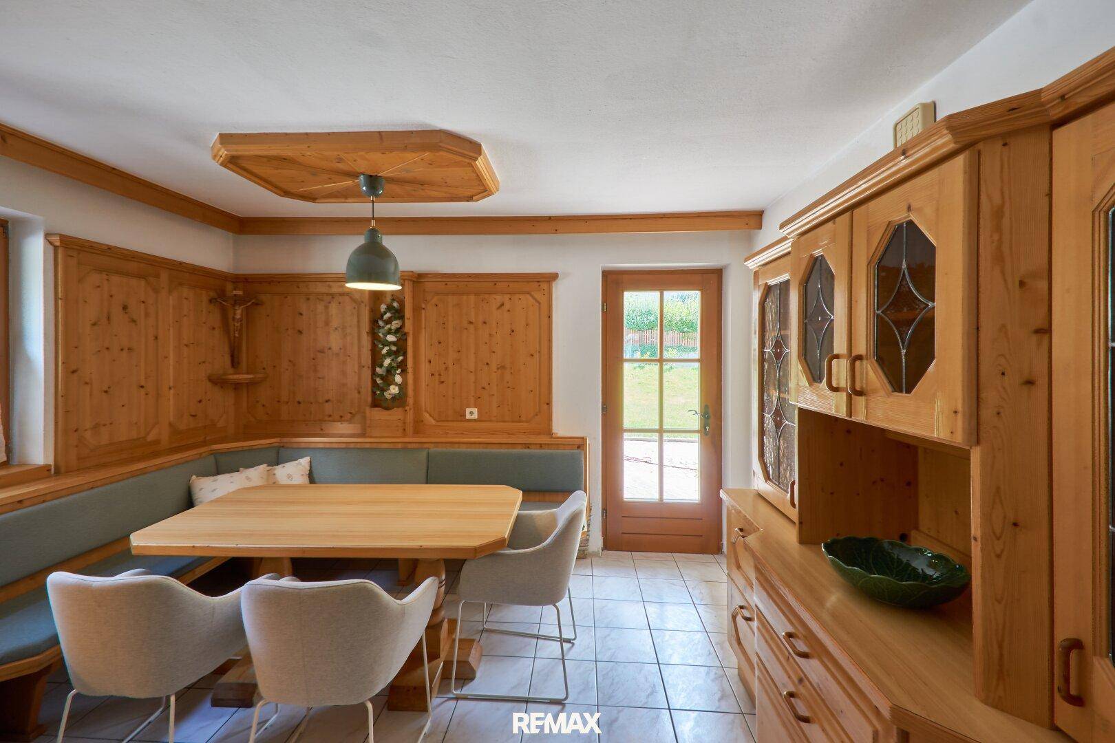 Traditioneller Essbereich mit Holztäfelung, Eckbank und einem großen Holztisch.