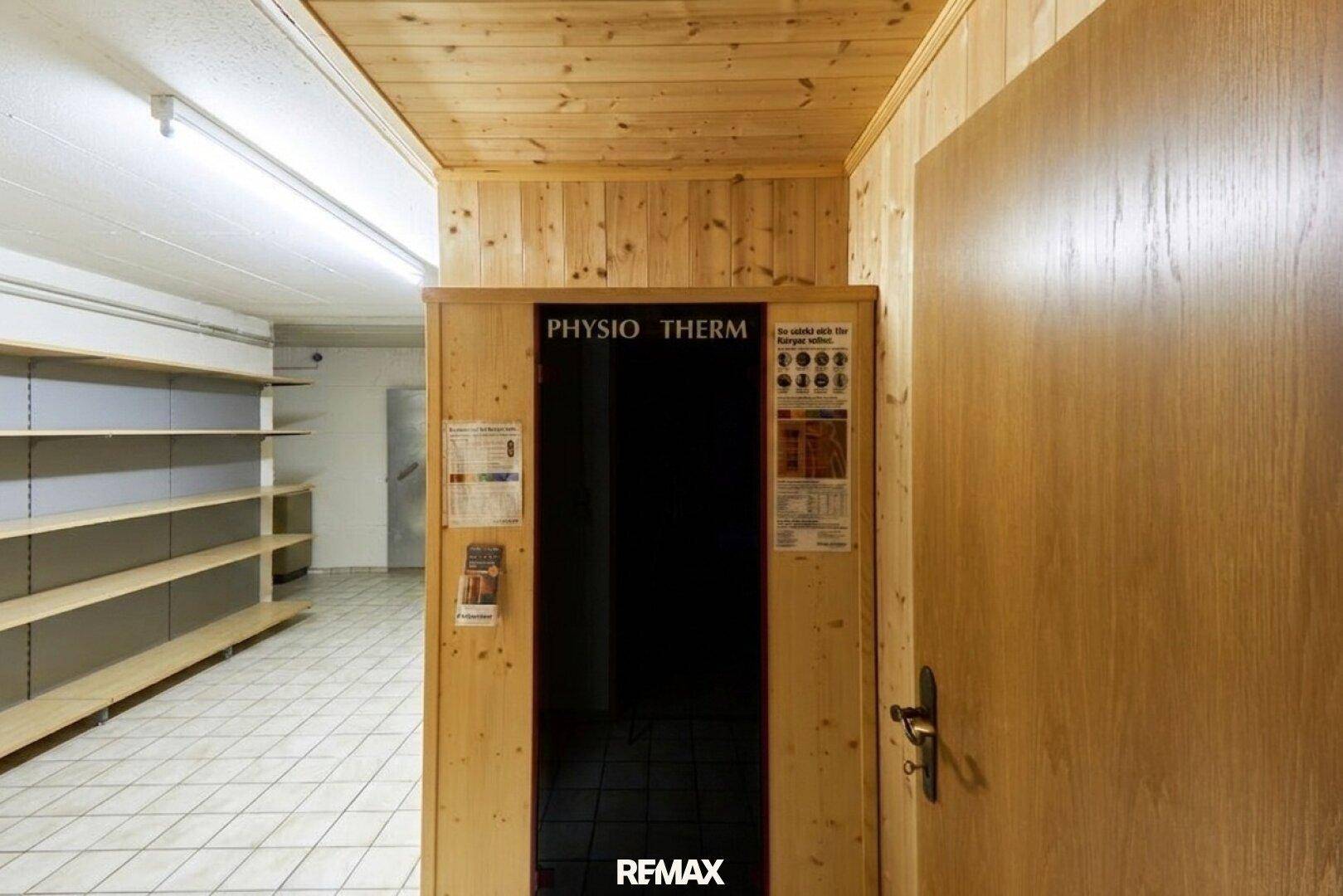 Wellnessbereich mit Infrarotkabine und Regalen in einem gefliesten Raum.