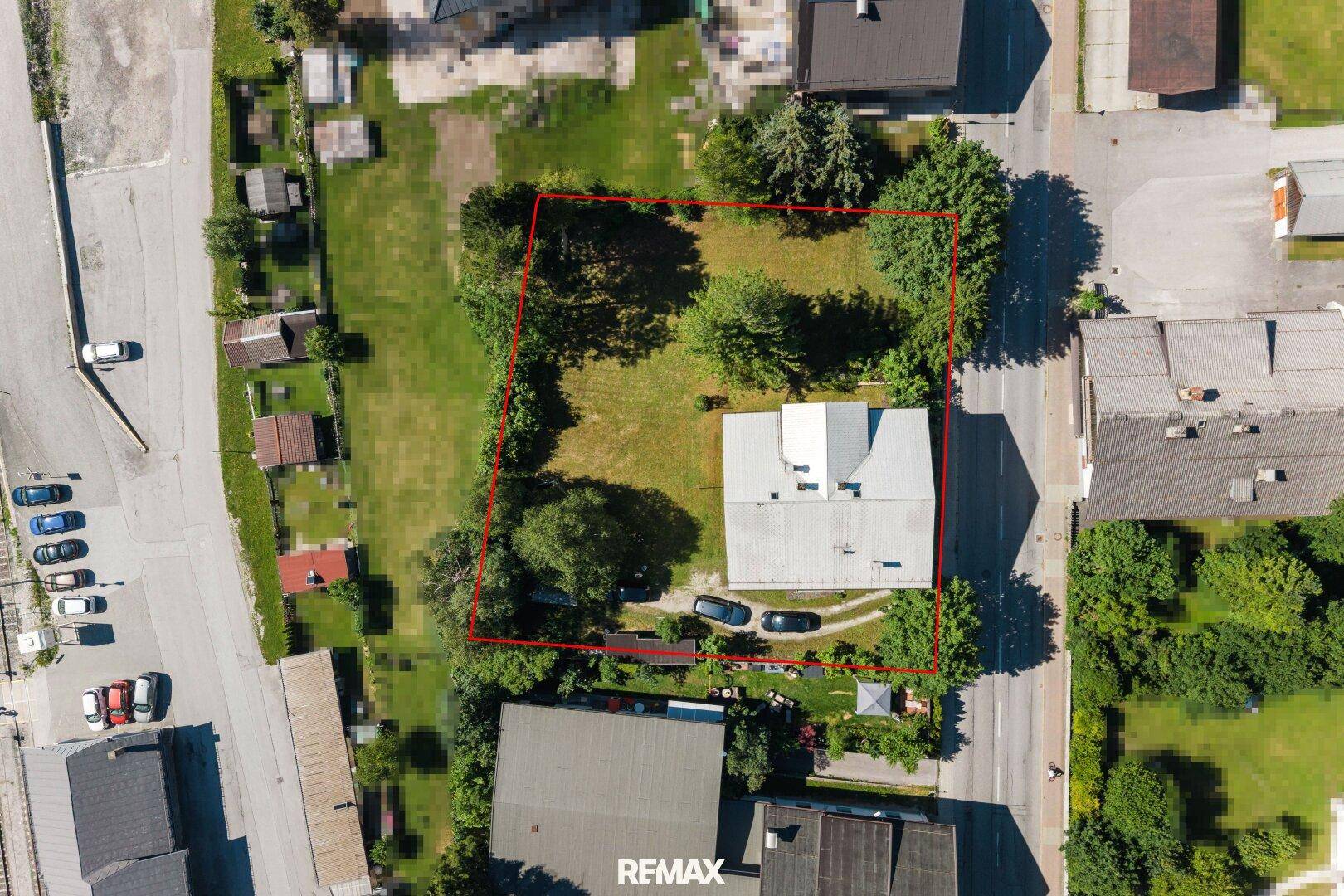 Luftaufnahme eines Grundstücks mit Wohnhaus und Gartenfläche, rot umrandet.