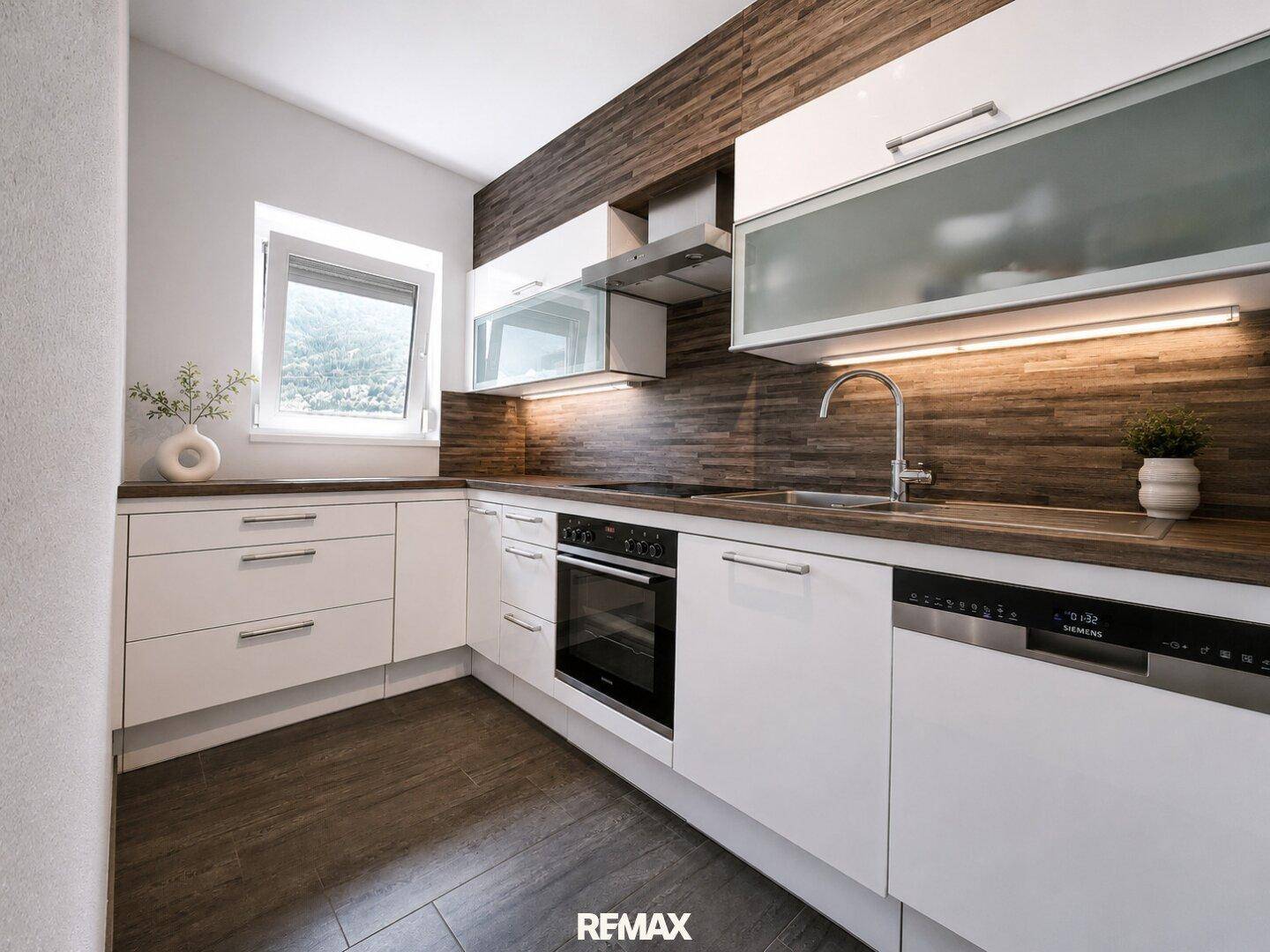 Moderne Küche mit weißen Schränken, Holzoptik-Arbeitsplatten und integrierten Siemens-Geräten.