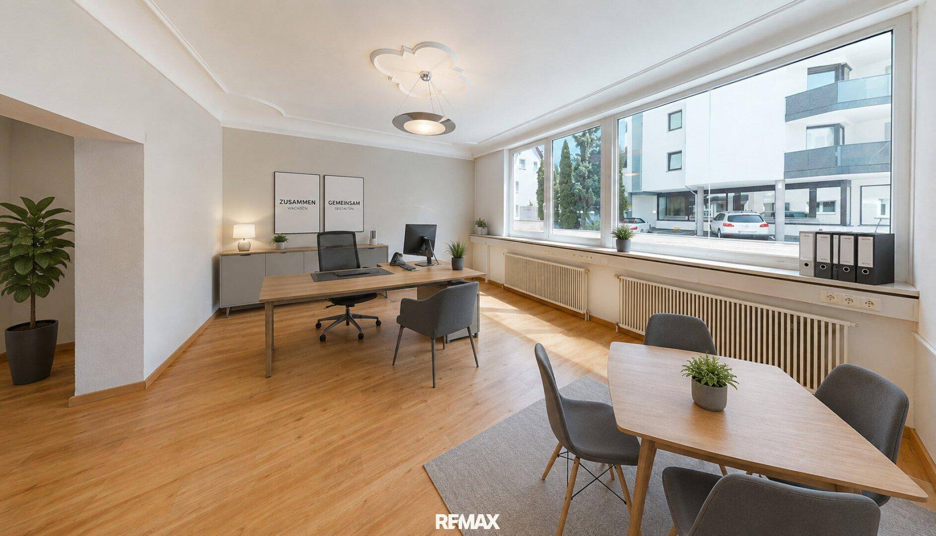 Geräumiges Büro mit mehreren Arbeitsplätzen, Besprechungstisch und großen Fenstern mit Ausblick.