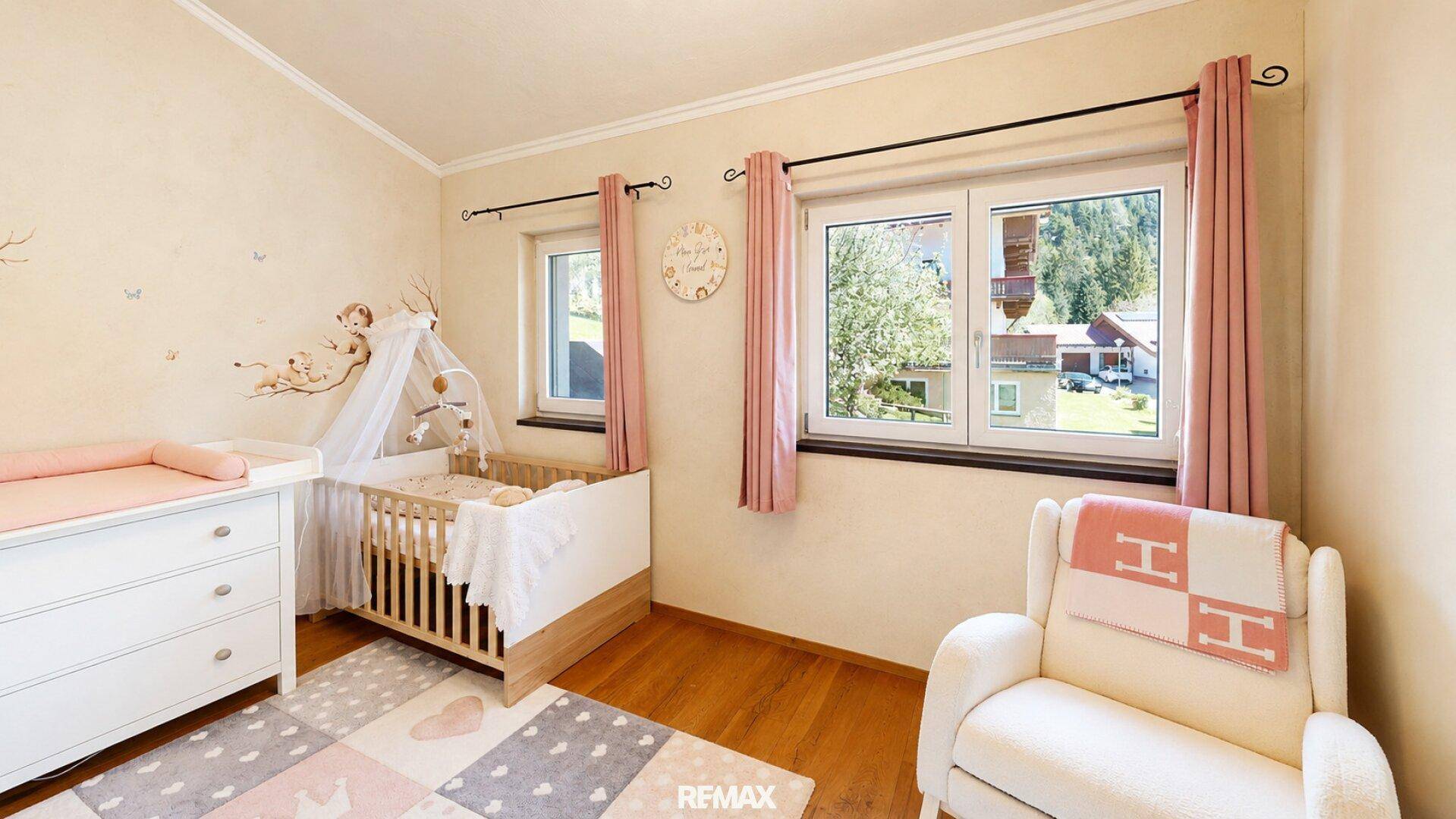 Helles Kinderzimmer mit Babybett, Wickeltisch und freundlicher Dekoration.
