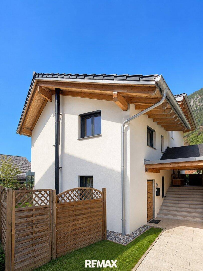 Seitenansicht des modernen Hauses mit Eingangsbereich und Holzverkleidung.