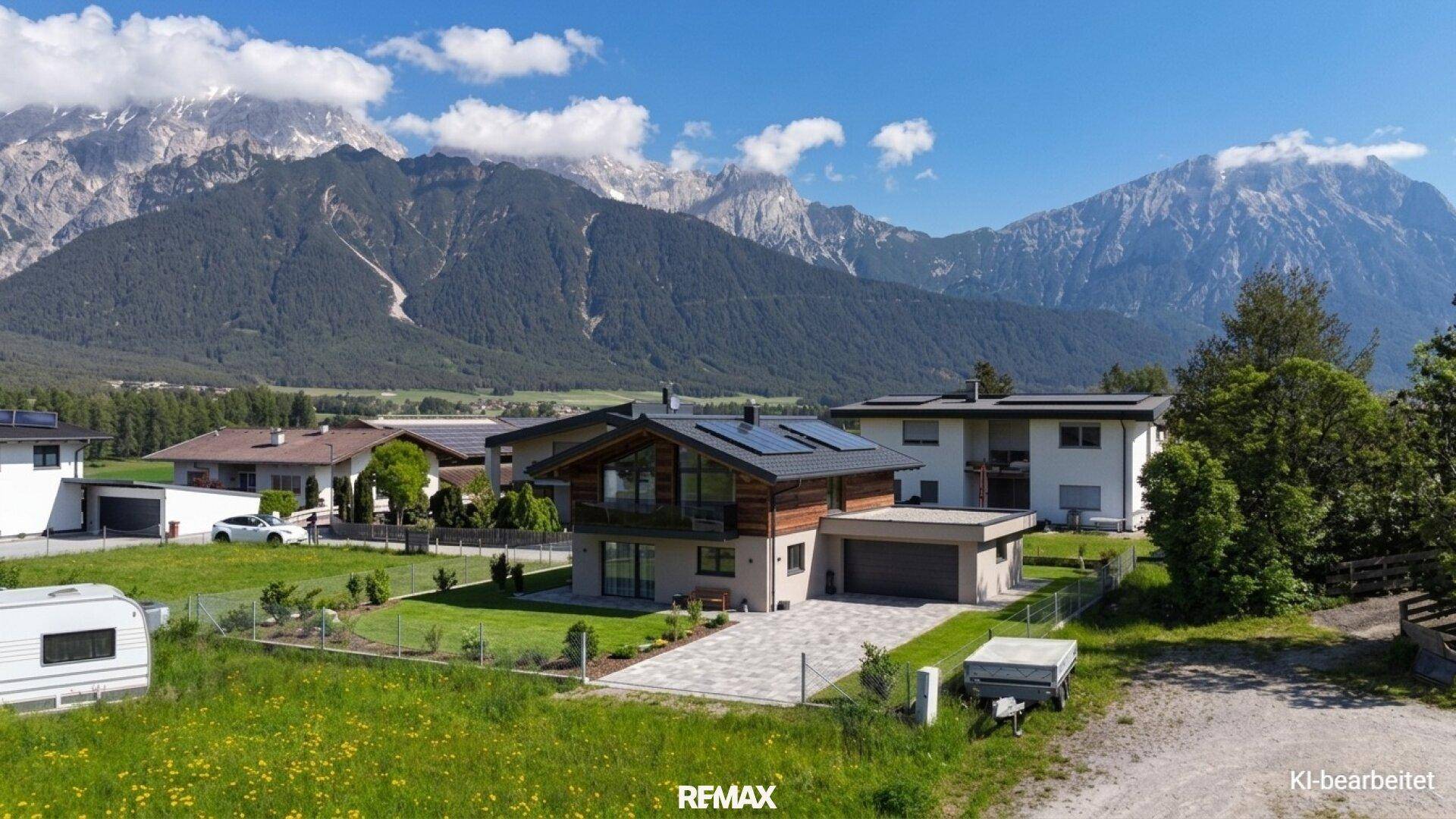 Attraktives Einfamilienhaus mit Holzfassade und Bergblick in ländlicher Umgebung, umgeben von Natur.