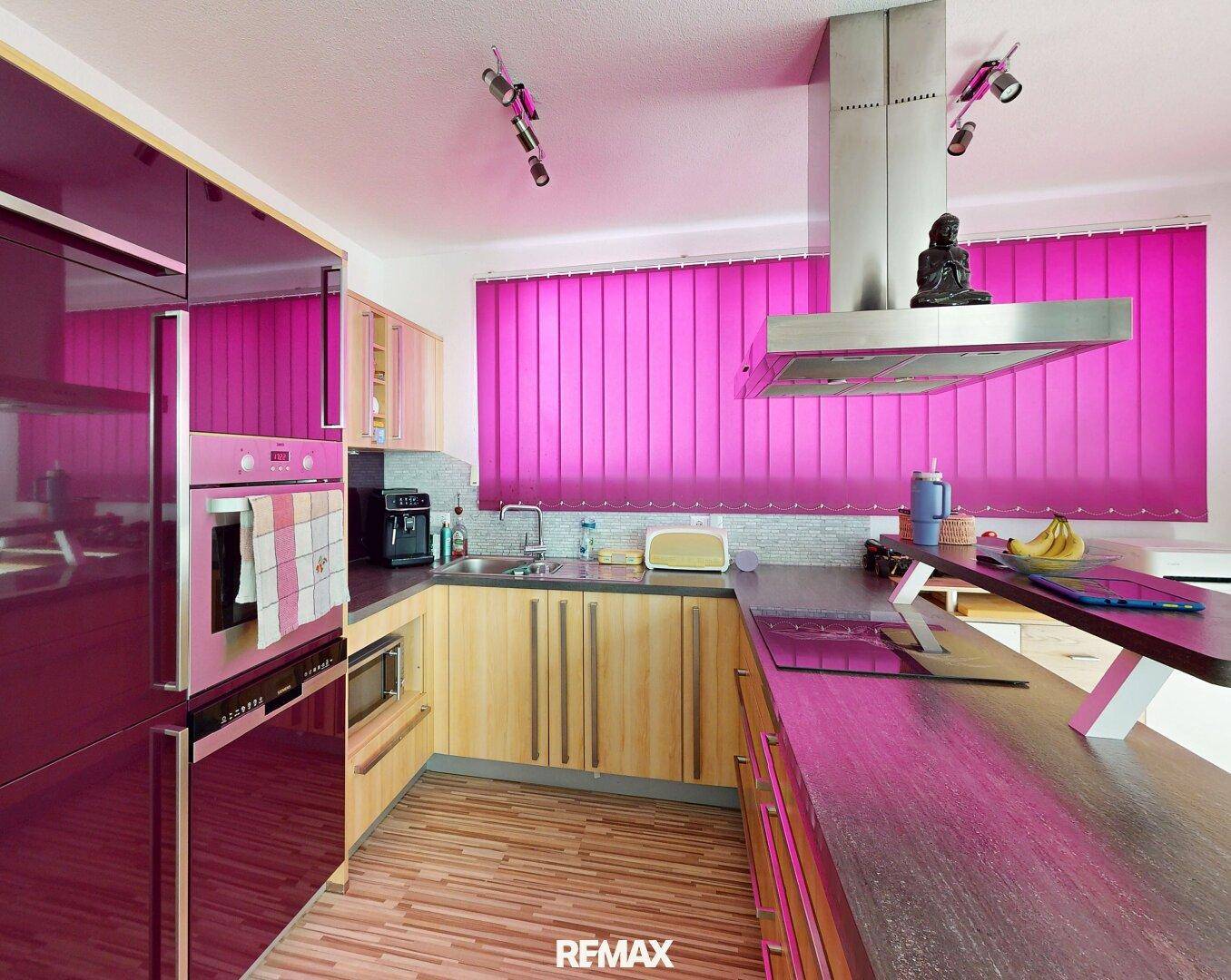 Moderne Küche mit glänzenden magenta Fronten, Holzelementen und Dunstabzugshaube.