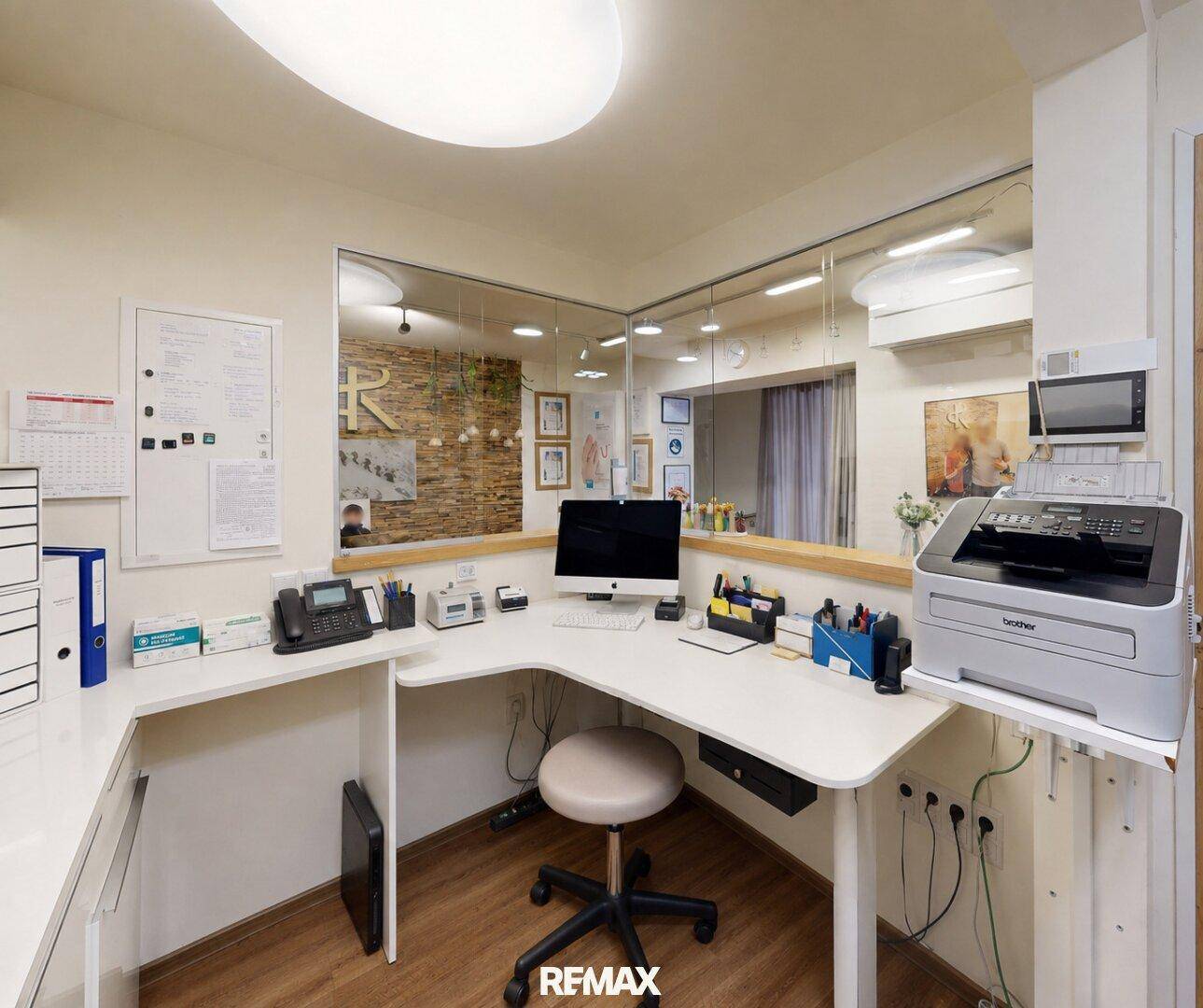 Moderner Empfangsbereich mit Schreibtisch, Computer und Drucker in einem Büro.