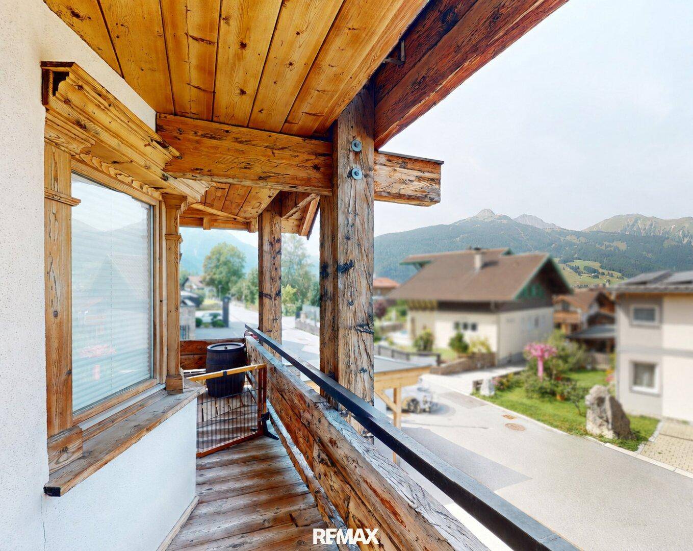 Geräumiger Holzbalkon mit Bergblick und traditionellen Holzelementen.