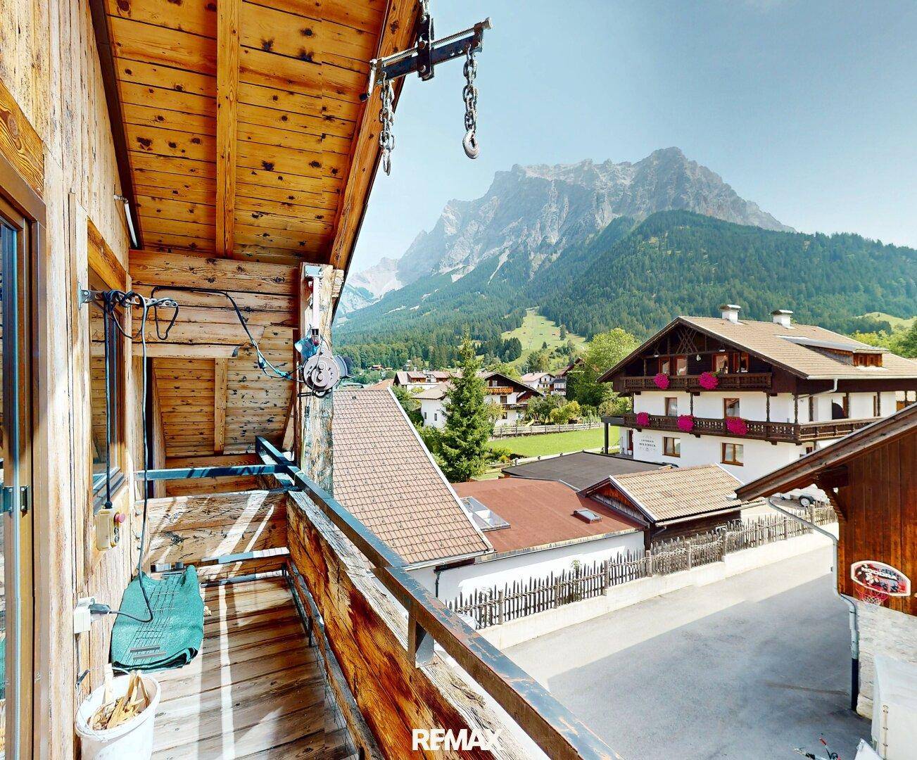 Rustikaler Holzbalkon mit Bergblick und traditioneller Holzverkleidung, ideal zum Entspannen.