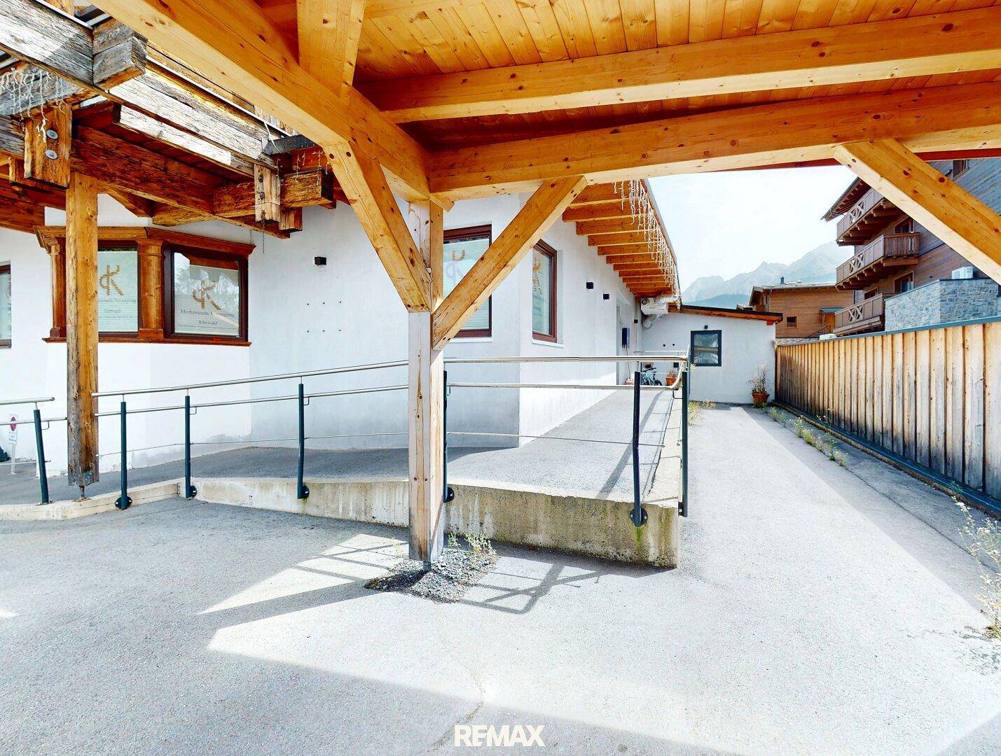 Barrierefreier Zugang zum Gebäude mit einer Rampe und Holzkonstruktion im alpinen Stil.