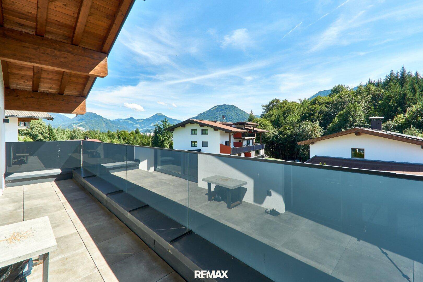 Großer Balkon mit Glasgeländer und atemberaubendem Panoramablick auf die Berge.