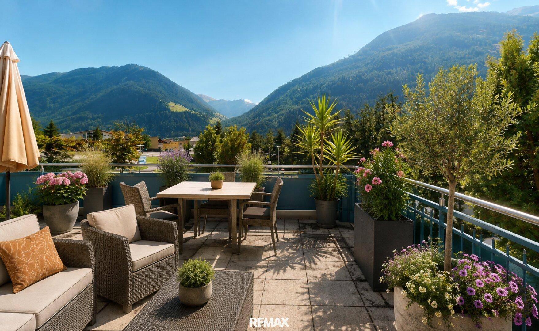 Große Sonnenterrasse mit Ess- und Lounge-Bereich, Pflanzen und weitem Bergblick.