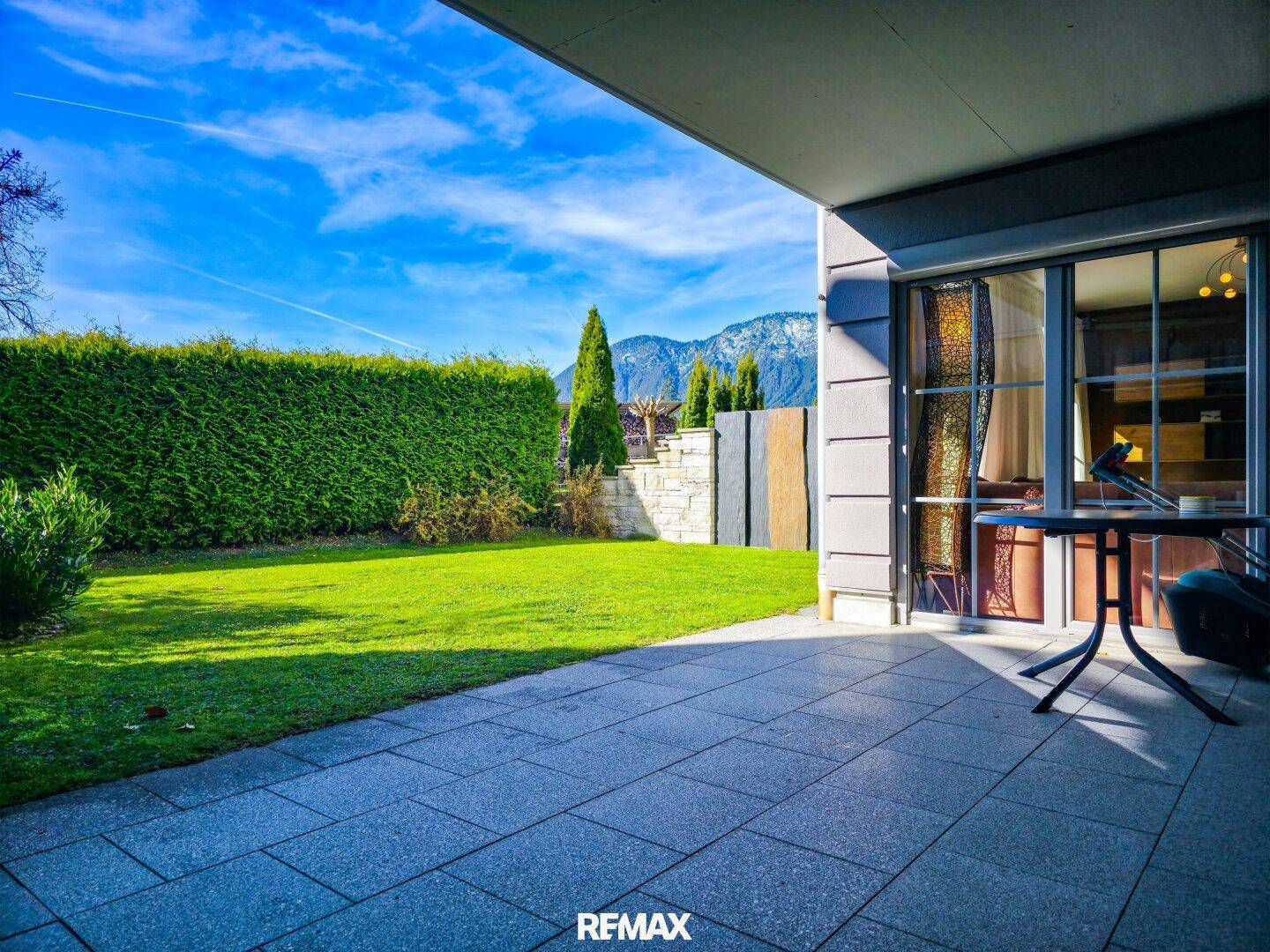Geräumige Terrasse mit Bergblick und Rasenfläche, ideal für Entspannung im Freien.