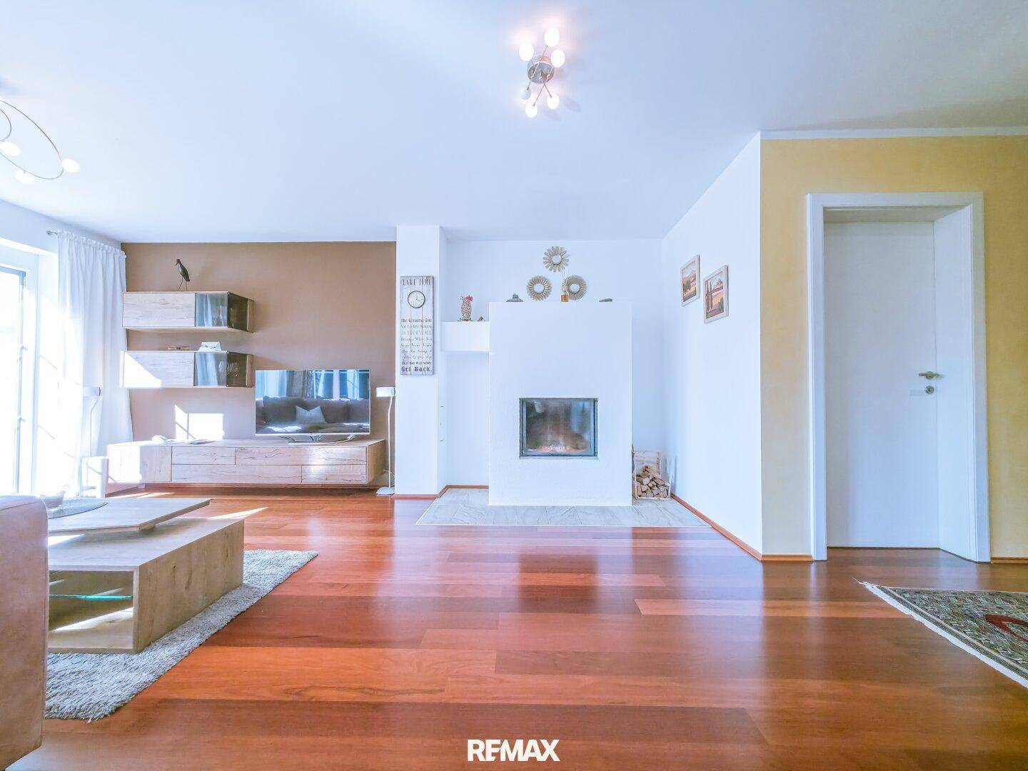 Gemütliches Wohnzimmer mit Kamin, Holzboden und moderner Einrichtung.