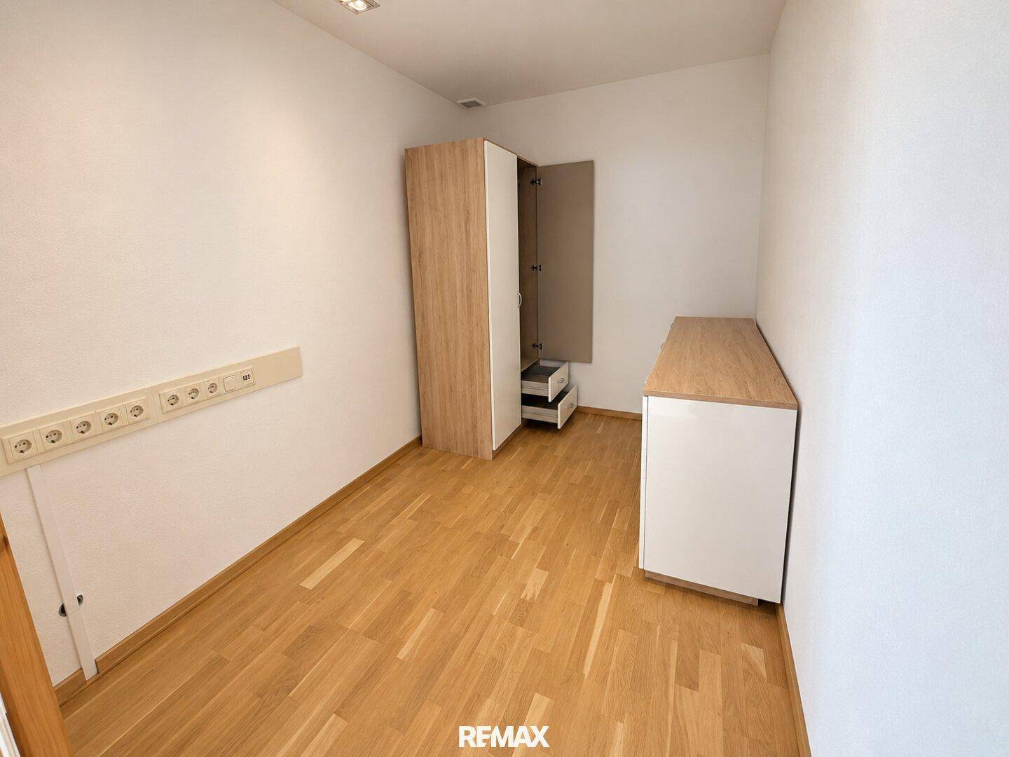 Kleines, helles Zimmer mit Parkettboden und einem Schrank, vielseitig nutzbar.