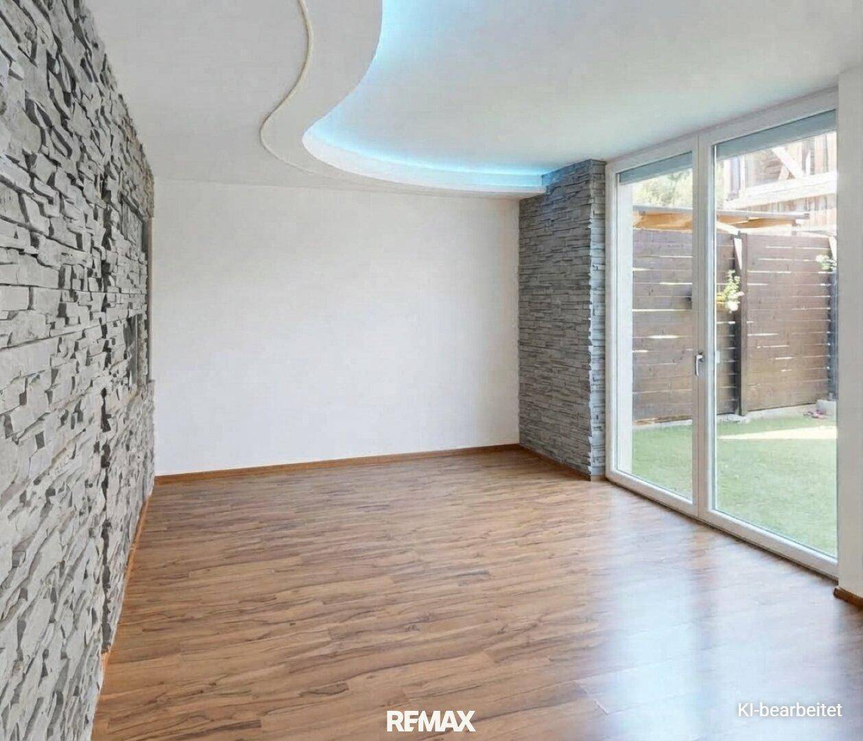 Heller Wohnraum mit dekorativer Steinwand, Holzfußboden und indirekter Deckenbeleuchtung.