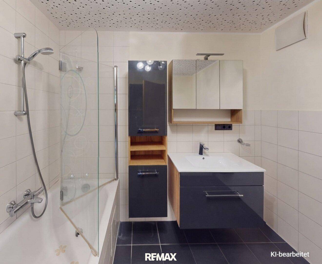 Modernes Badezimmer mit Badewanne, Duschfunktion, Waschtisch und praktischen Spiegelschränken.