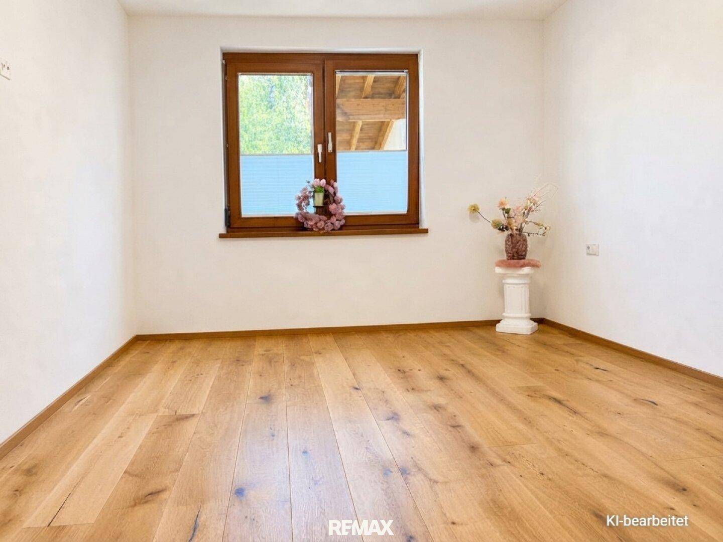 Heller Raum mit Holzboden und Fenster, bereit zur individuellen Gestaltung.
