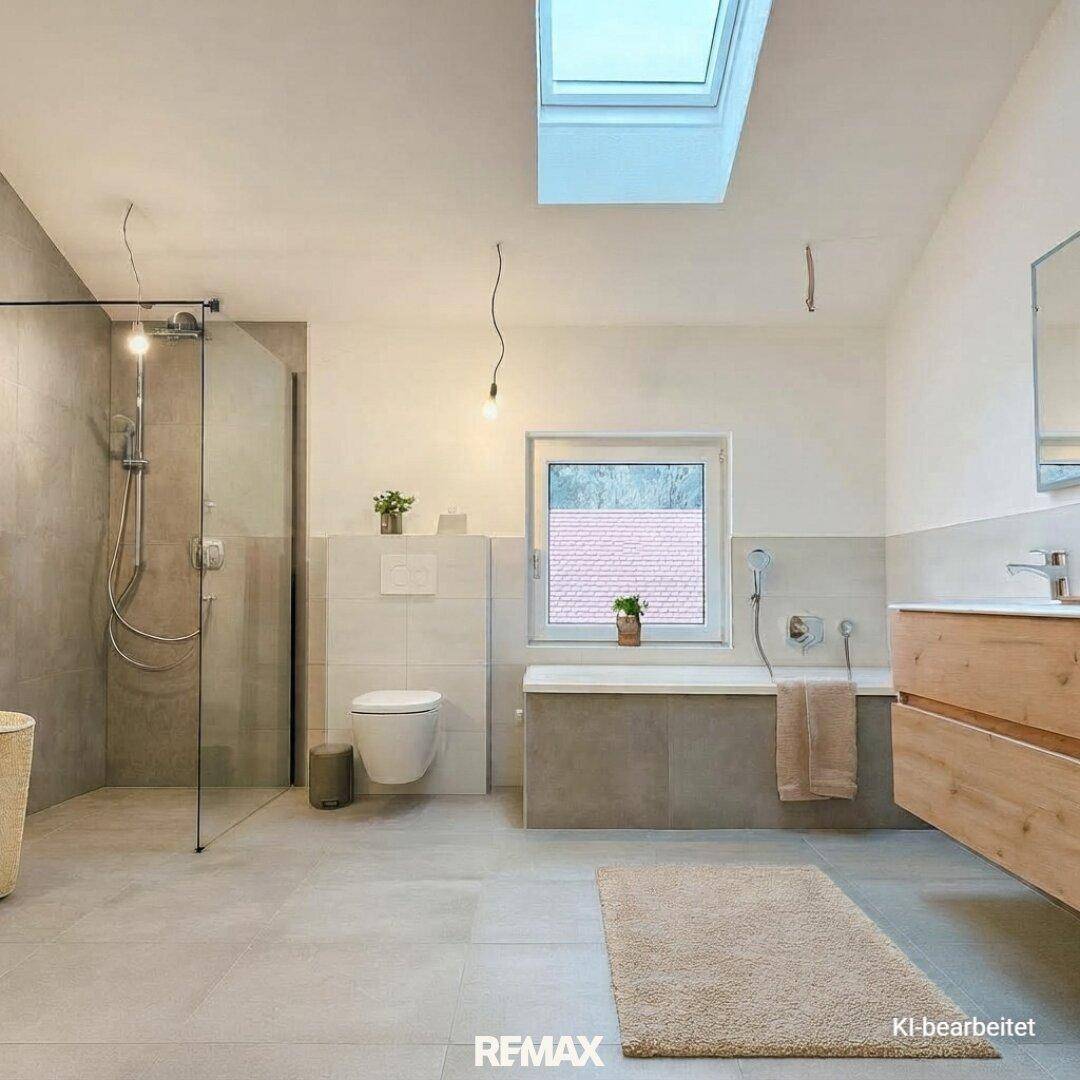 Modernes Badezimmer mit begehbarer Dusche, Badewanne und viel Tageslicht durch Dachfenster und Fenster.