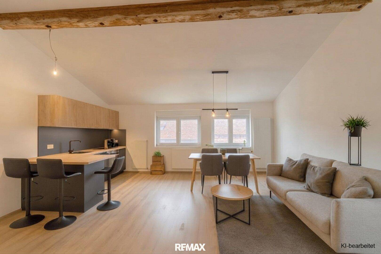 Offener Wohn- und Essbereich mit moderner Küche, Holzbalken und viel Platz für geselliges Beisammensein.