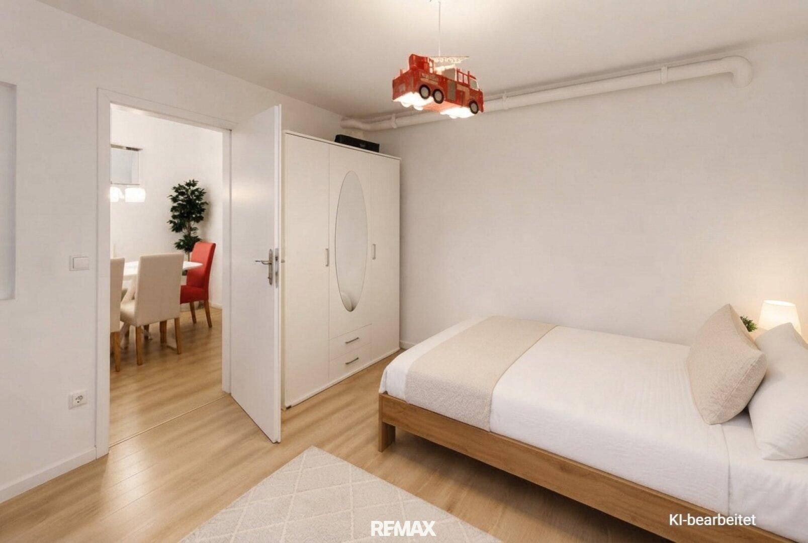 Helles Schlafzimmer mit Einzelbett, Kleiderschrank und Zugang zum Essbereich.
