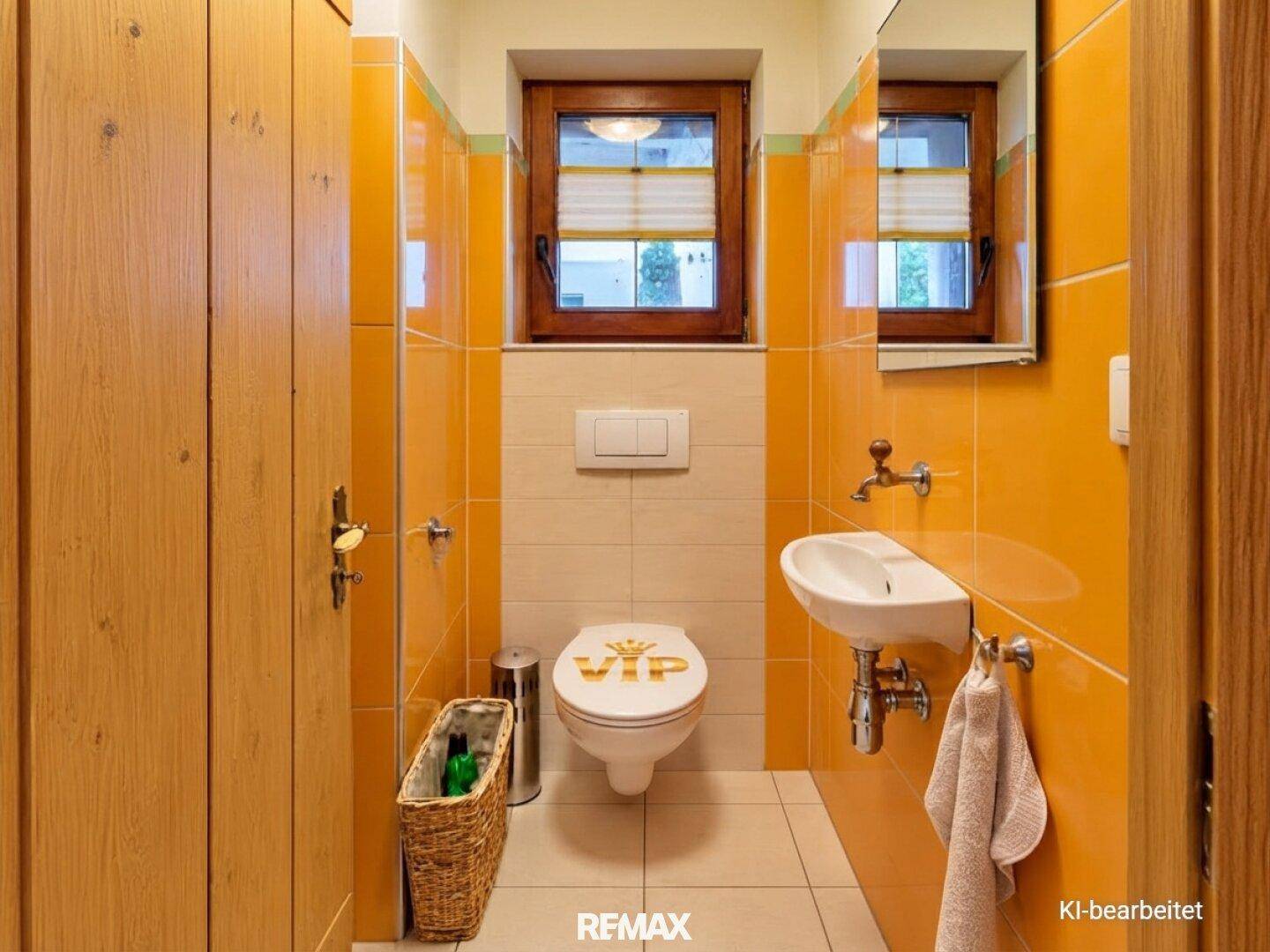Kleines Gäste-WC mit orangefarbenen Fliesen, Fenster und Waschbecken.