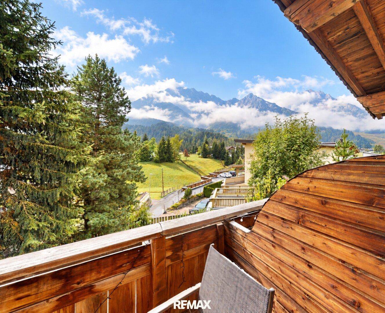 Balkon mit Holzboden und atemberaubendem Bergblick, ideal zum Entspannen im Freien.