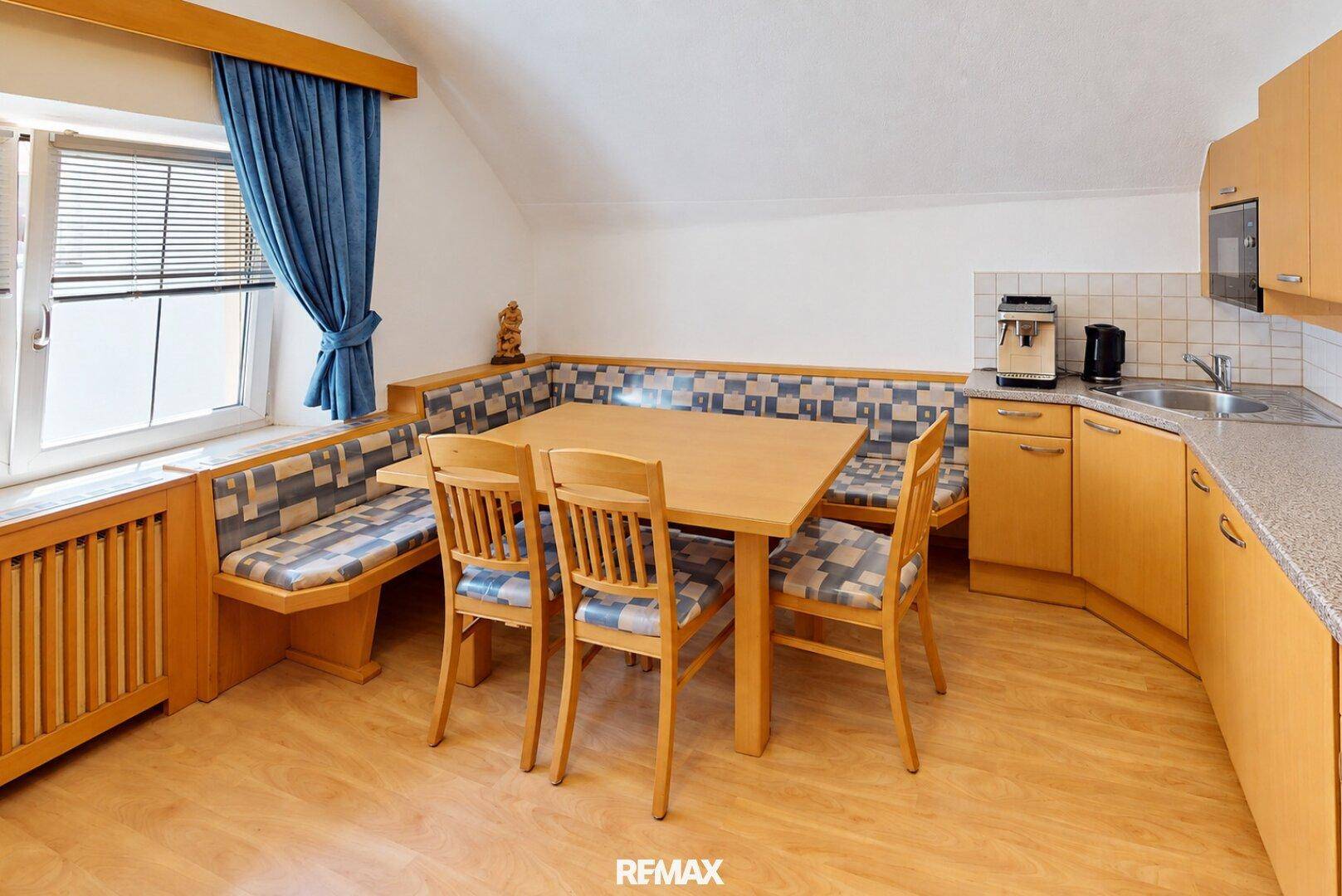 Gemütliche Wohnküche mit Eckbank, Esstisch und Holzstühlen, ideal für gemeinsame Mahlzeiten.