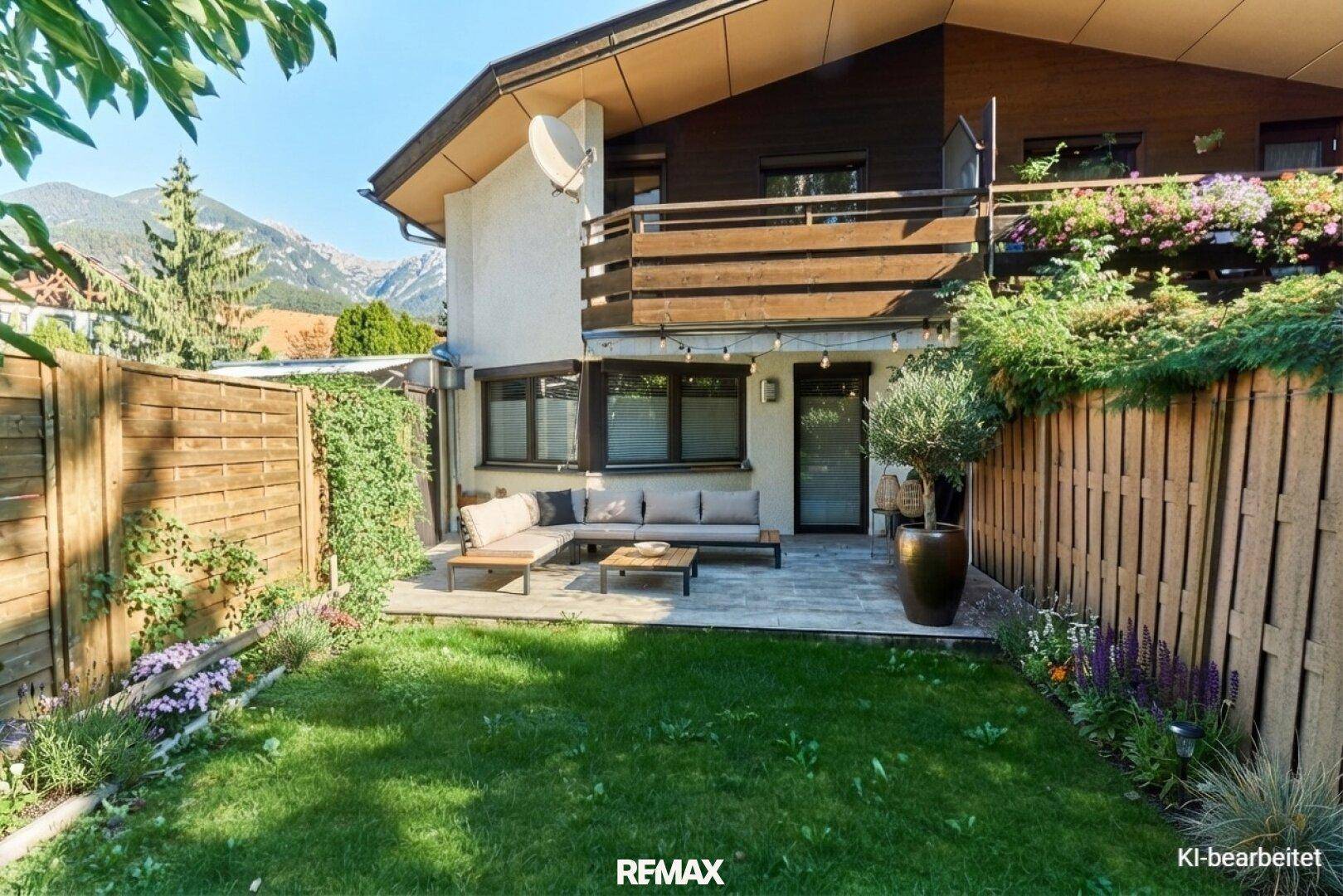 Gemütliche Terrasse mit Gartenmöbeln, Rasenfläche und herrlichem Bergblick.