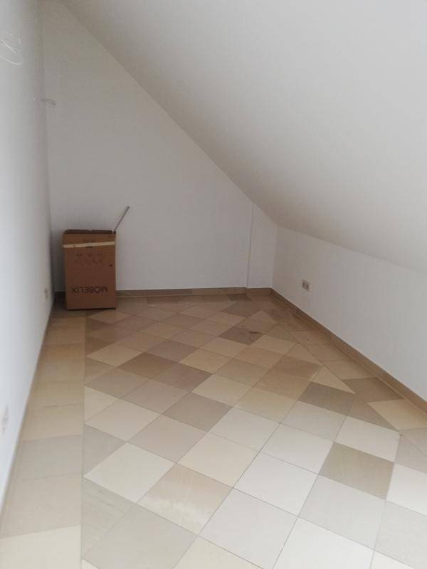 Kleiner Dachgeschossraum mit schrägen Wänden und gemusterten Fliesenboden, geeignet als Abstellraum.