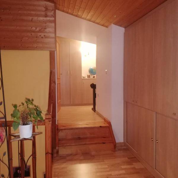 Heller Flur mit Holztreppe, Holzdecken und praktischen Einbauschränken, die viel Stauraum bieten.