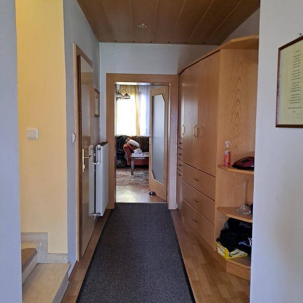 Heller Flur mit Holzdecke, Einbauschränken und Blick in ein angrenzendes Zimmer.