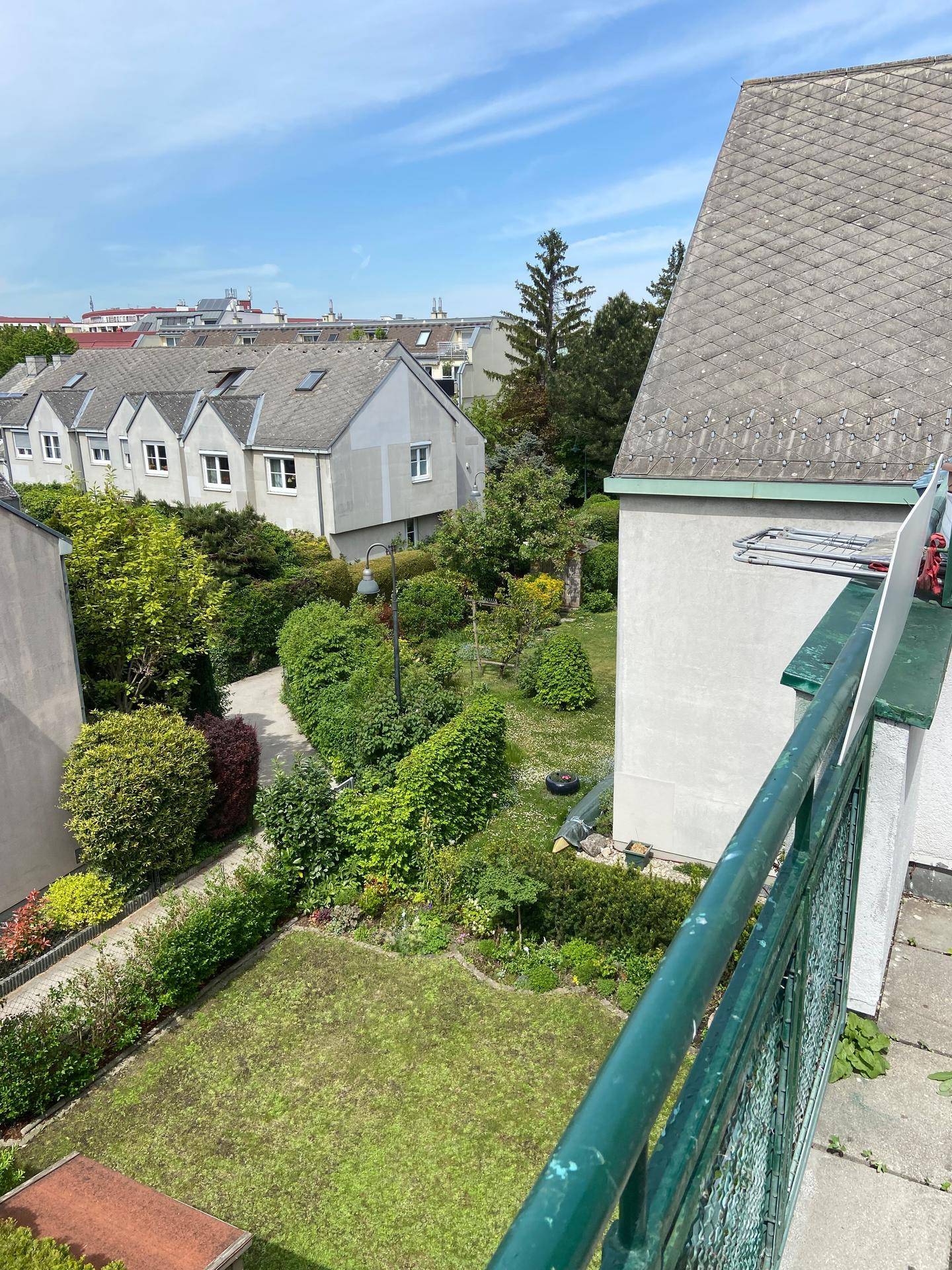 Ausblick auf einen Gemeinschaftsgarten und die umliegenden Wohnhäuser.