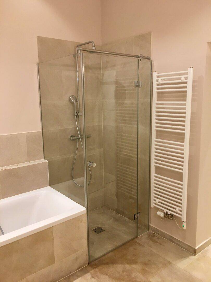 Modernes Badezimmer mit einer geräumigen Glasdusche und einem praktischen Handtuchheizkörper.