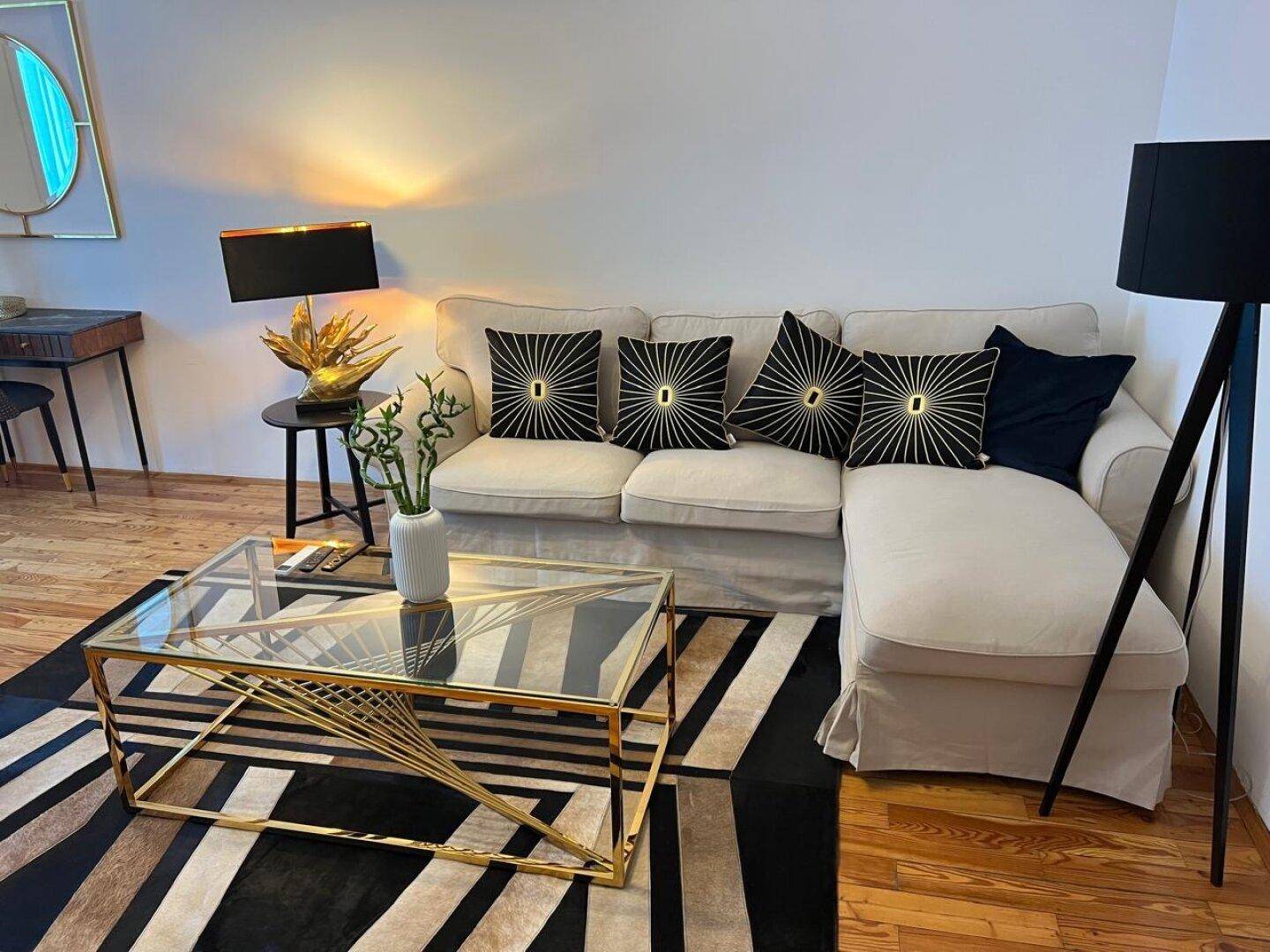 Gemütliches Wohnzimmer mit beigem Ecksofa, modernem Couchtisch und stilvollen Dekokissen.