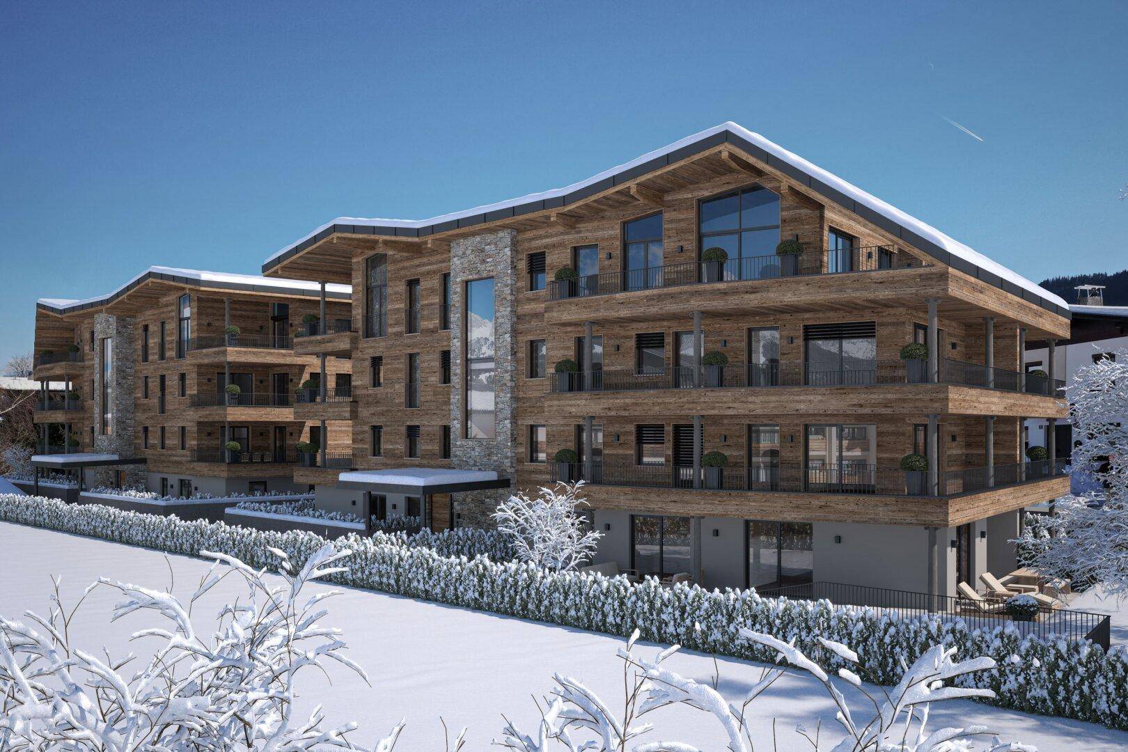 Modernes Mehrfamilienhaus in Holzbauweise mit Balkonen und verschneiter Umgebung im Winter.