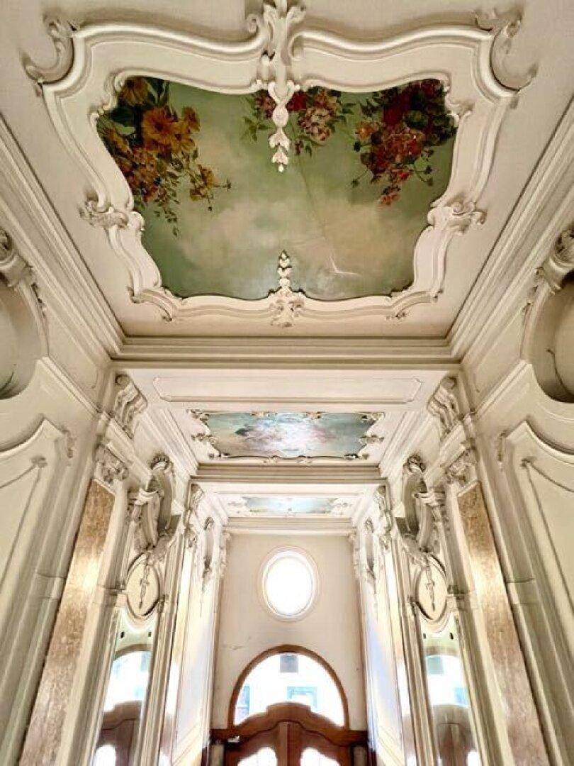 Prunkvolles Treppenhaus mit kunstvollen Stuckdecken, Wandmalereien und Marmorverkleidungen.