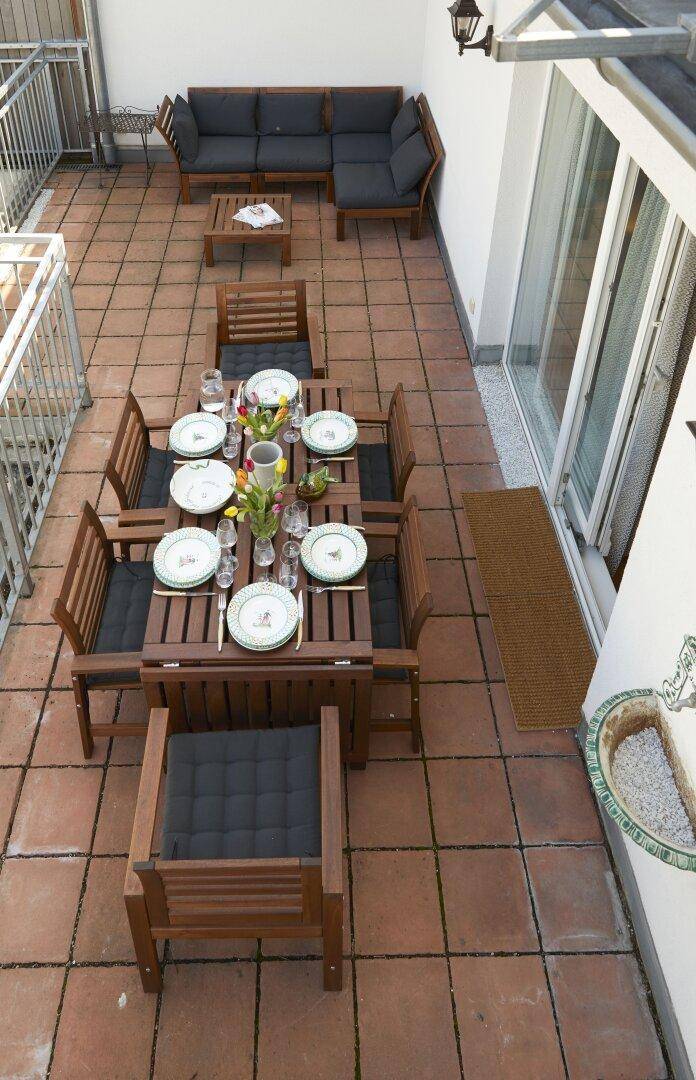 Geräumige Dachterrasse mit Essbereich und Lounge-Möbeln, ideal für Entspannung im Freien.