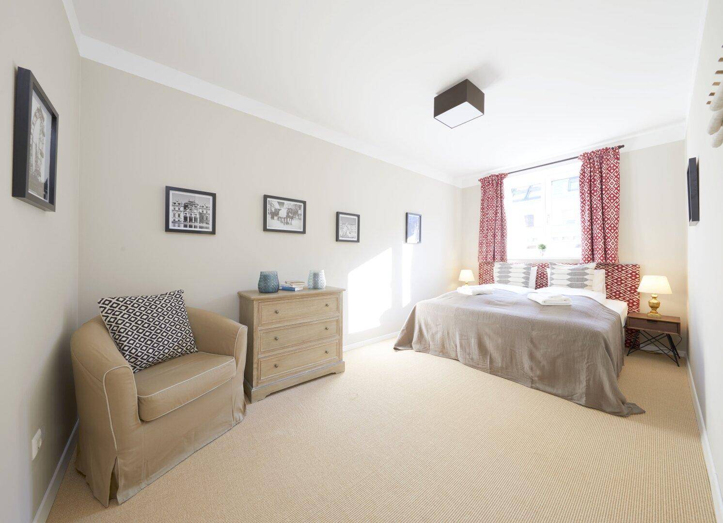 Komfortables Schlafzimmer mit Teppichboden, Doppelbett und moderner Einrichtung.