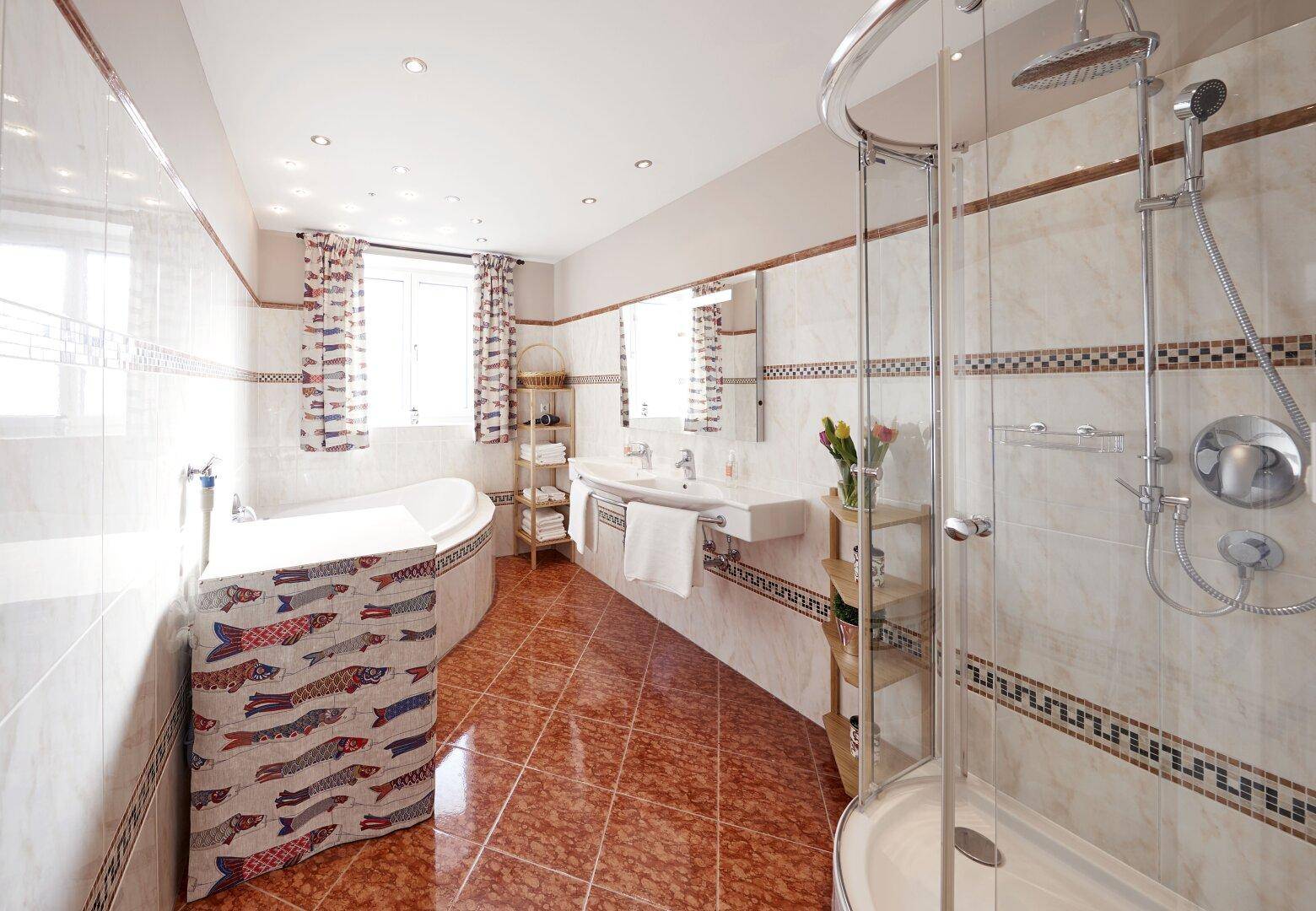 Geräumiges Badezimmer mit Badewanne, Dusche, Doppelwaschbecken und Fenster.