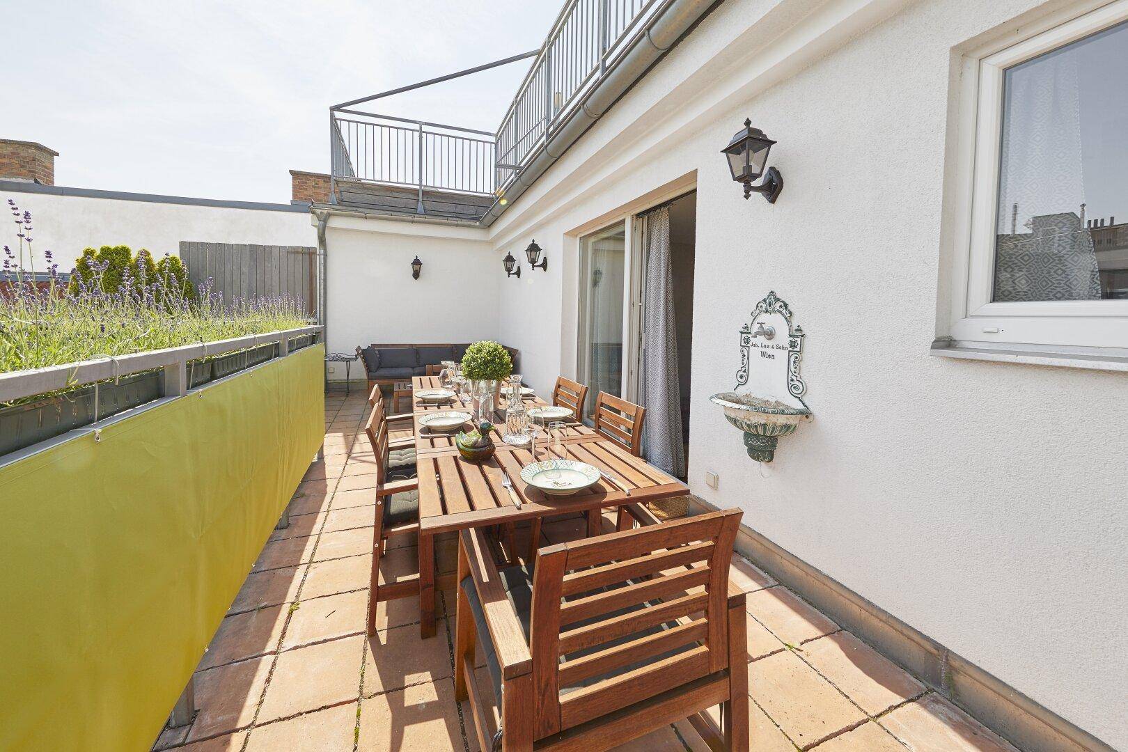 Große Dachterrasse mit Essbereich, Lounge-Möbeln und Blick auf die Umgebung.